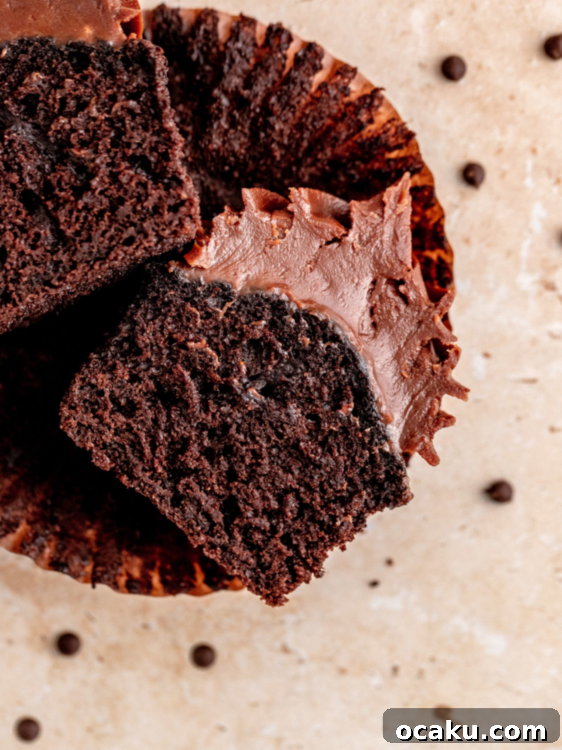 Chocolate Fudge Cupcakes cut in half, revealing moist interior and thick frosting.