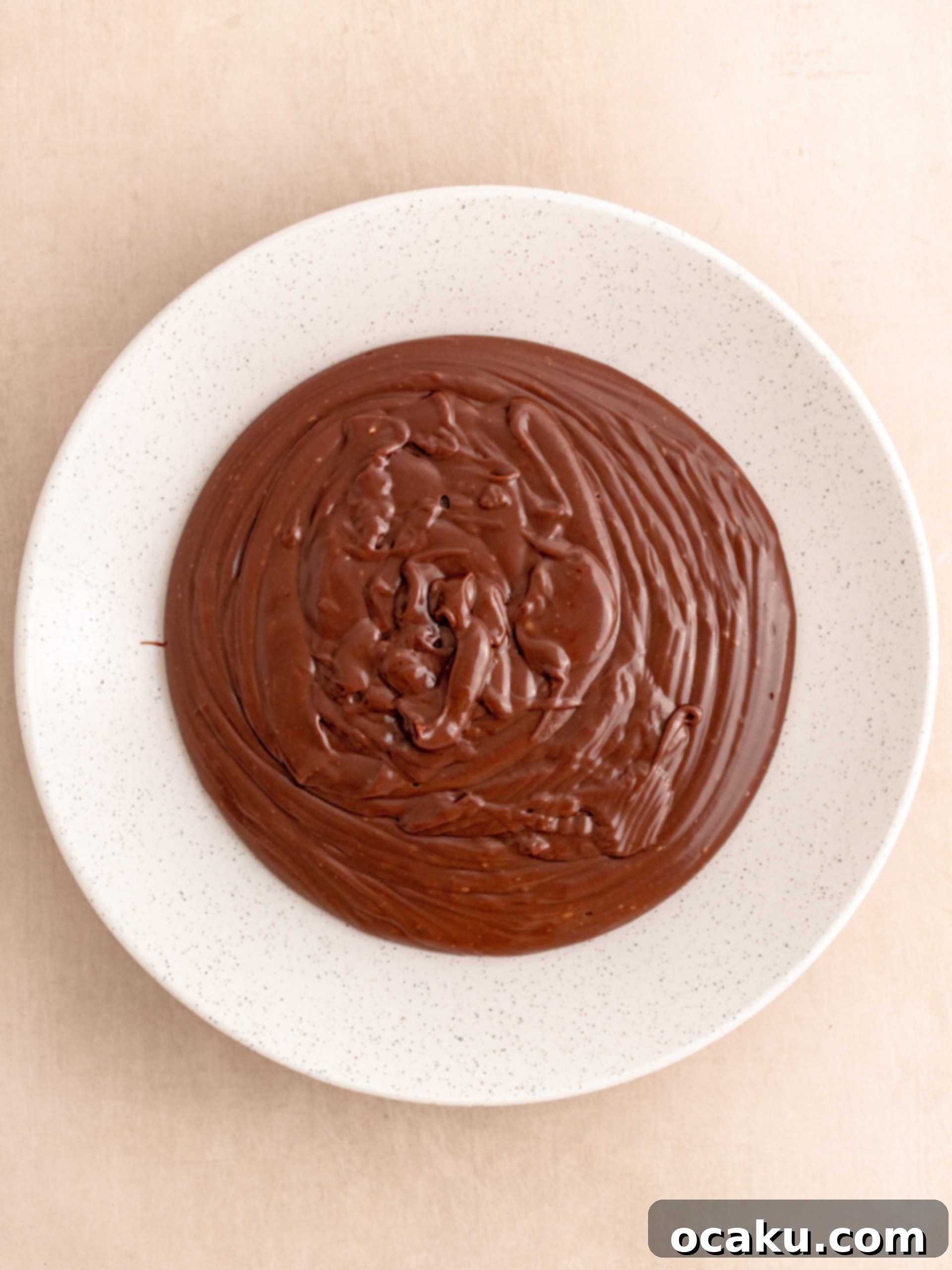 Smooth chocolate fudge frosting cooling in a bowl