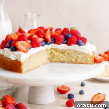 Fresh Berry Cream Cake with various berries on top, a slice cut out