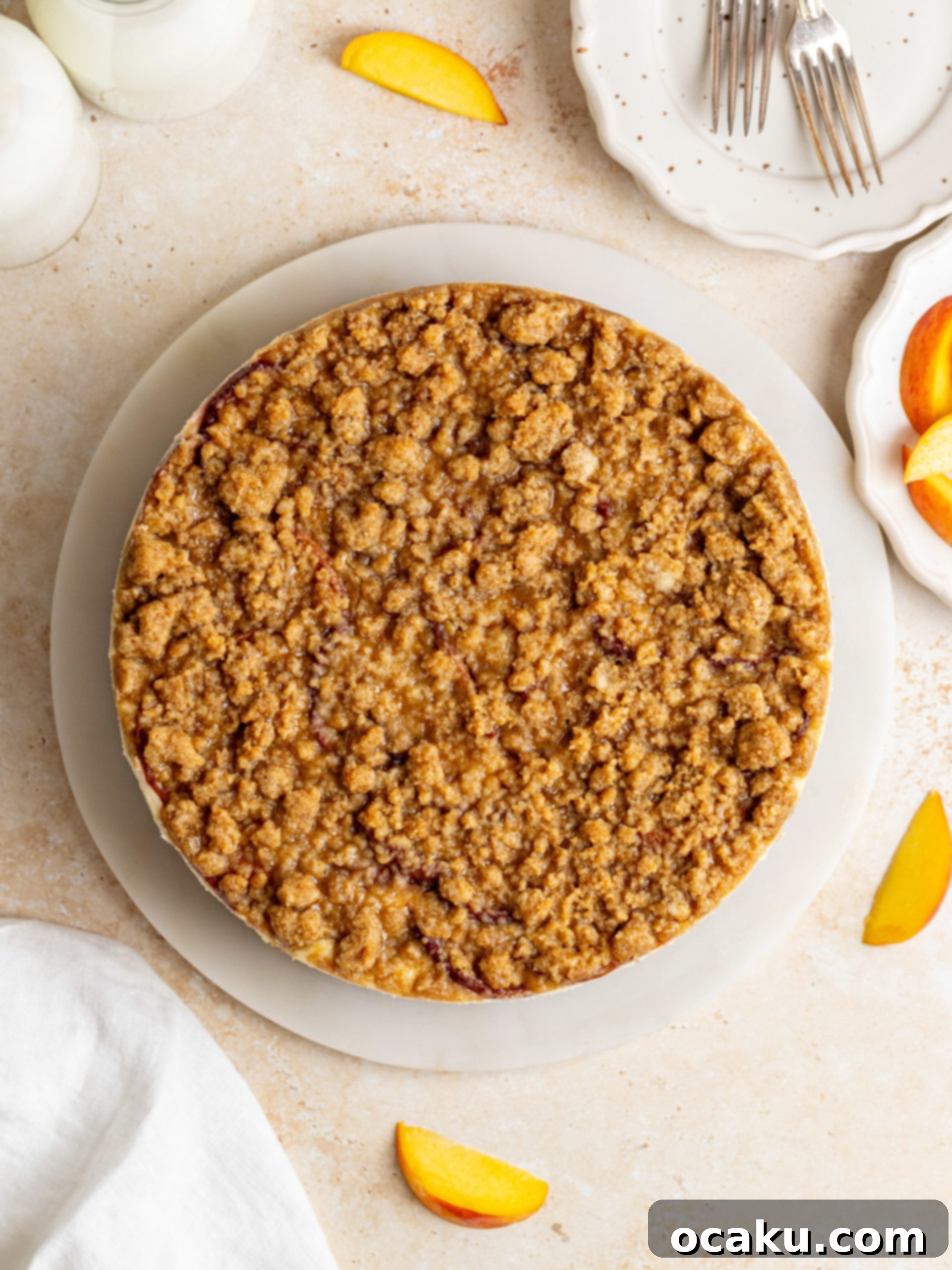 Assembled peach crumble cheesecake ready for baking, with crumble topping.