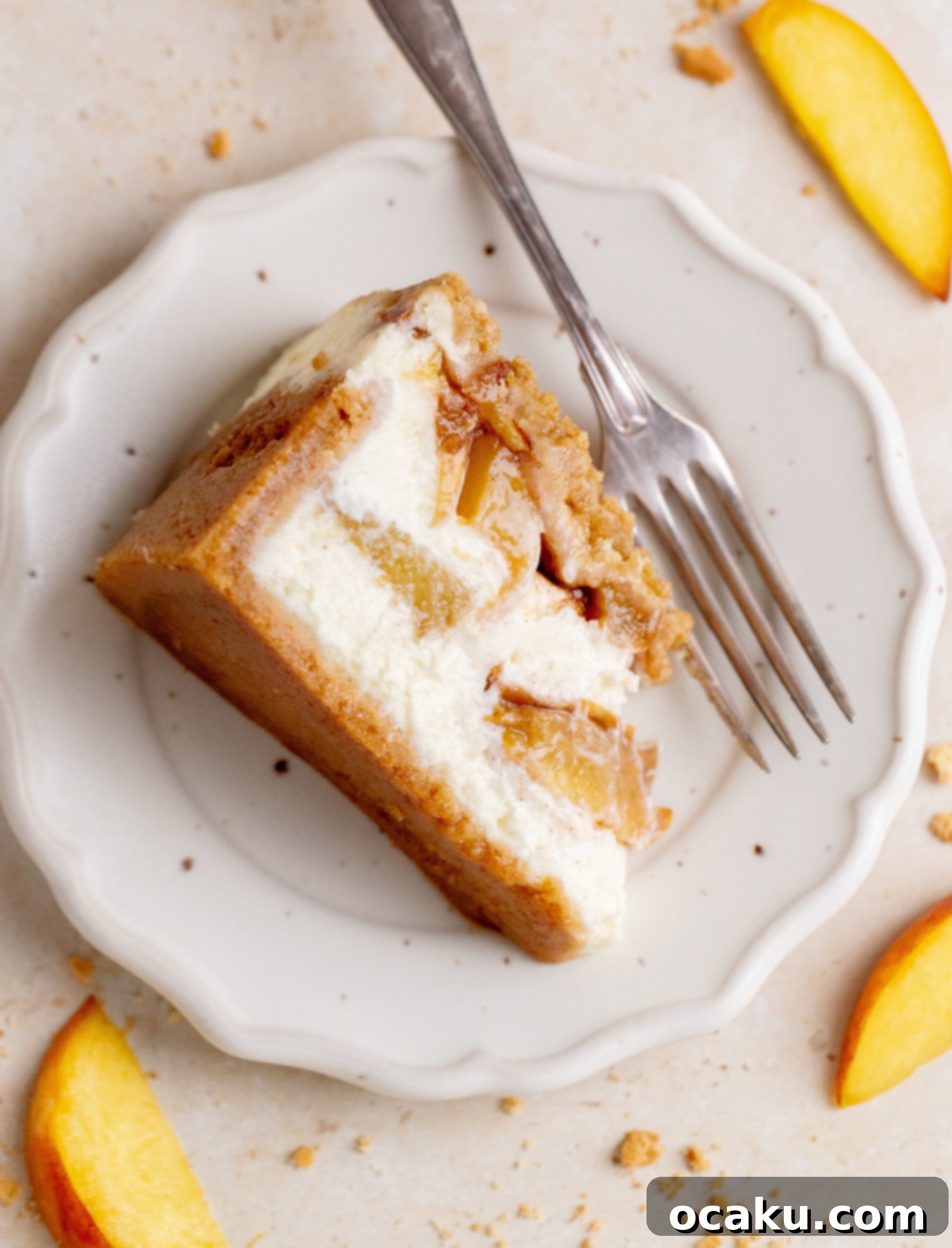 A beautifully sliced peach crumble cheesecake on a serving platter, showing off the layers.