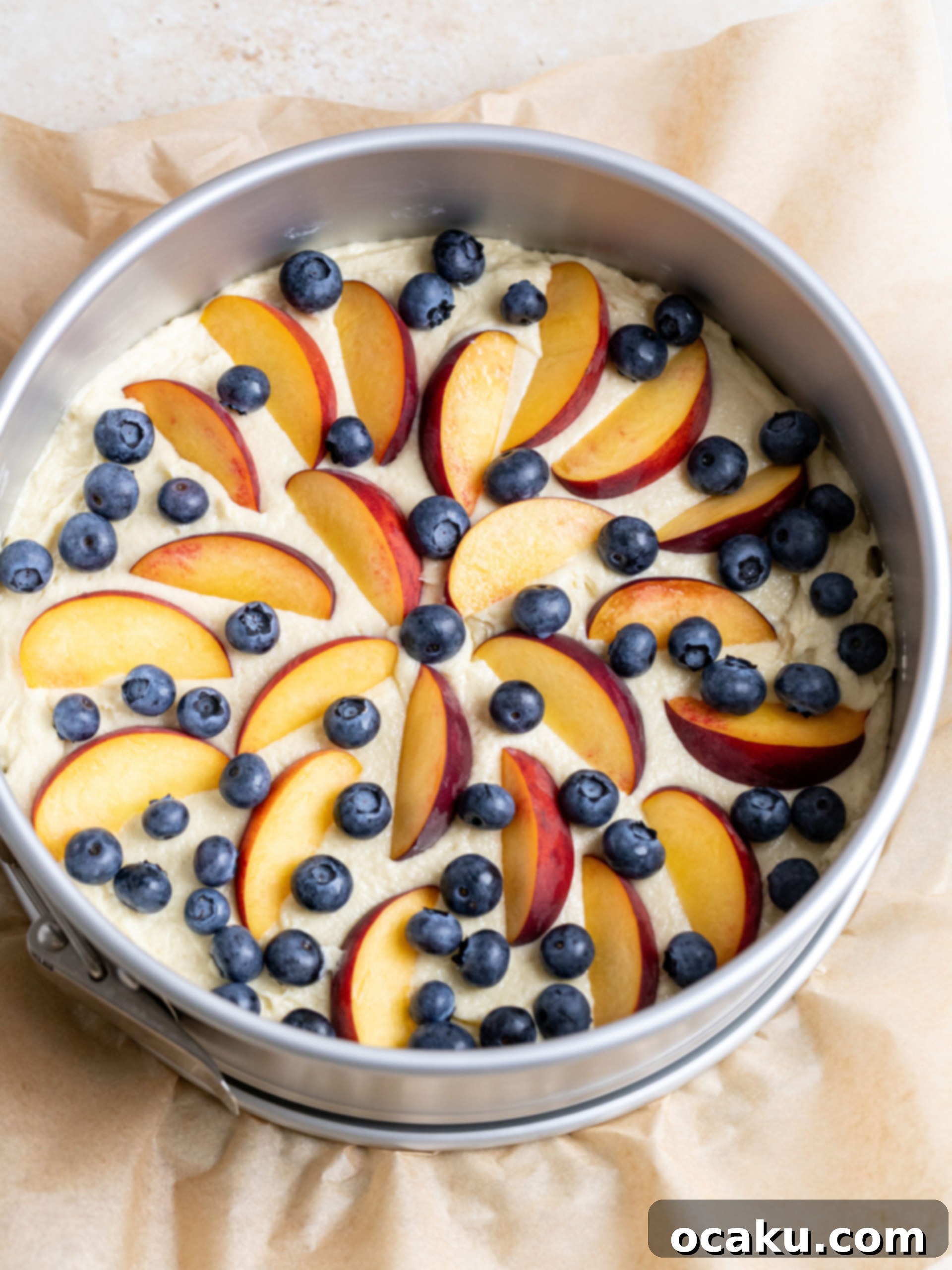 Cake batter being poured into a prepared springform pan.