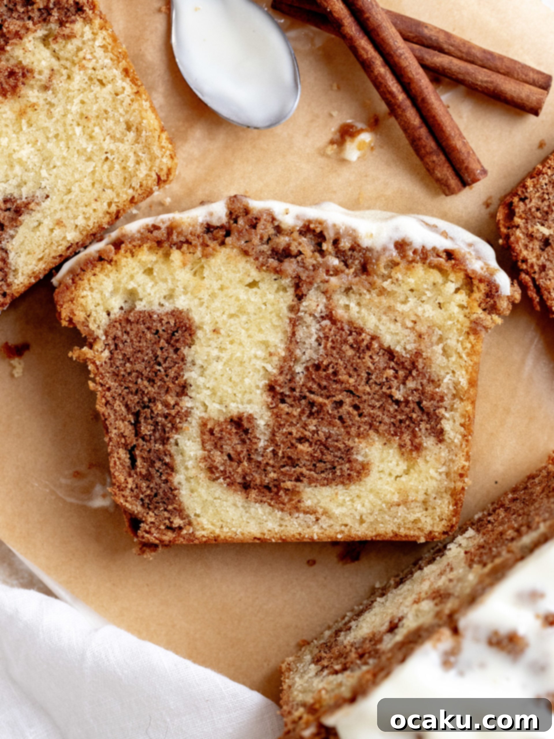 Slice of Cinnamon Loaf Cake with visible cinnamon swirl, streusel topping, and cream cheese glaze