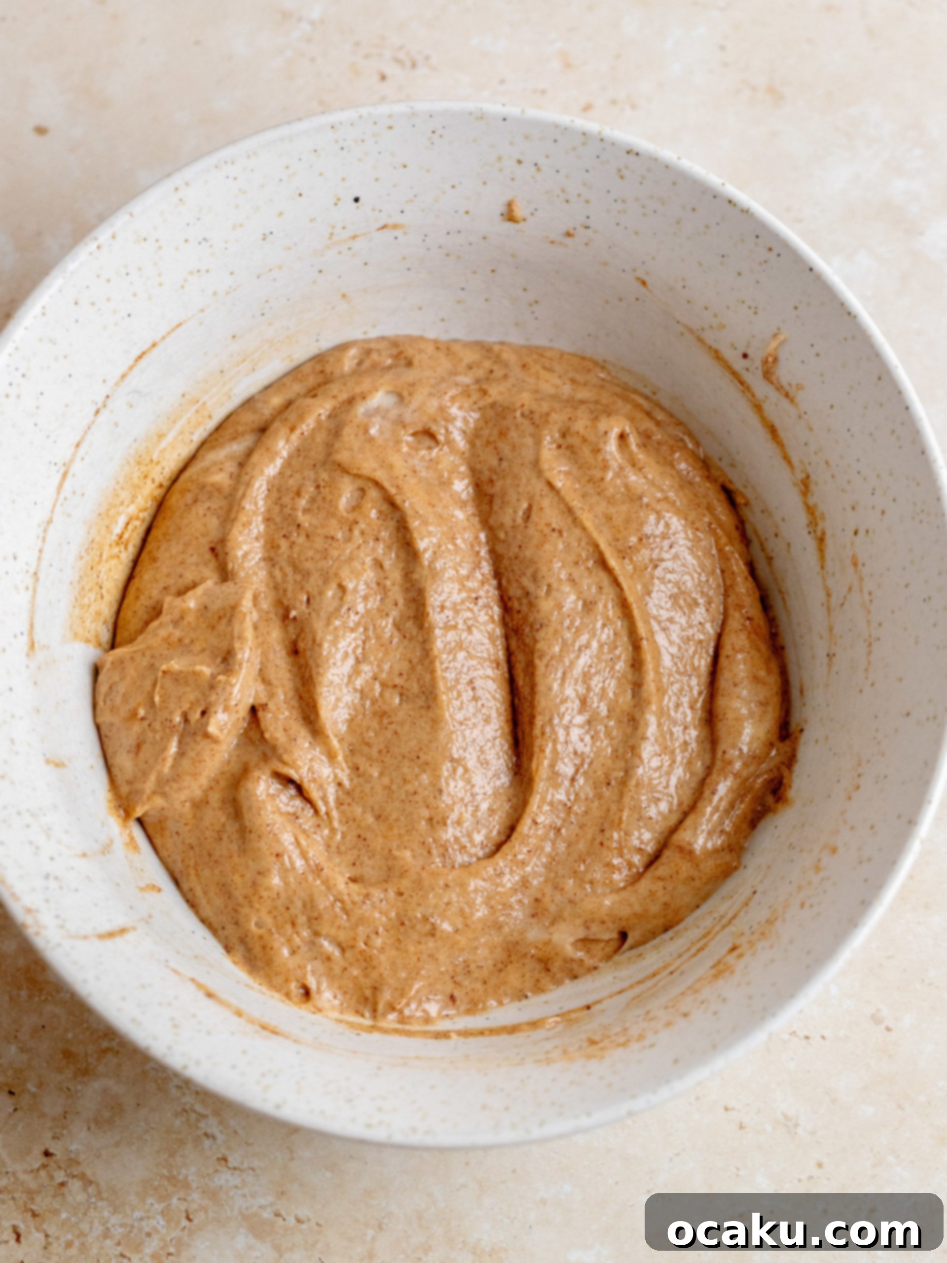 Cake pan with alternating layers of plain and cinnamon batter, ready for swirling