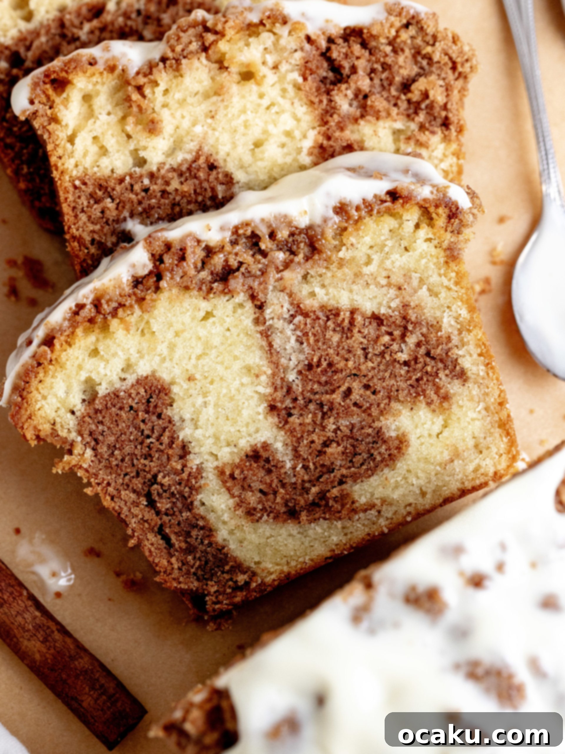 Overhead view of Cinnamon Loaf Cake on a cooling rack, freshly glazed and garnished