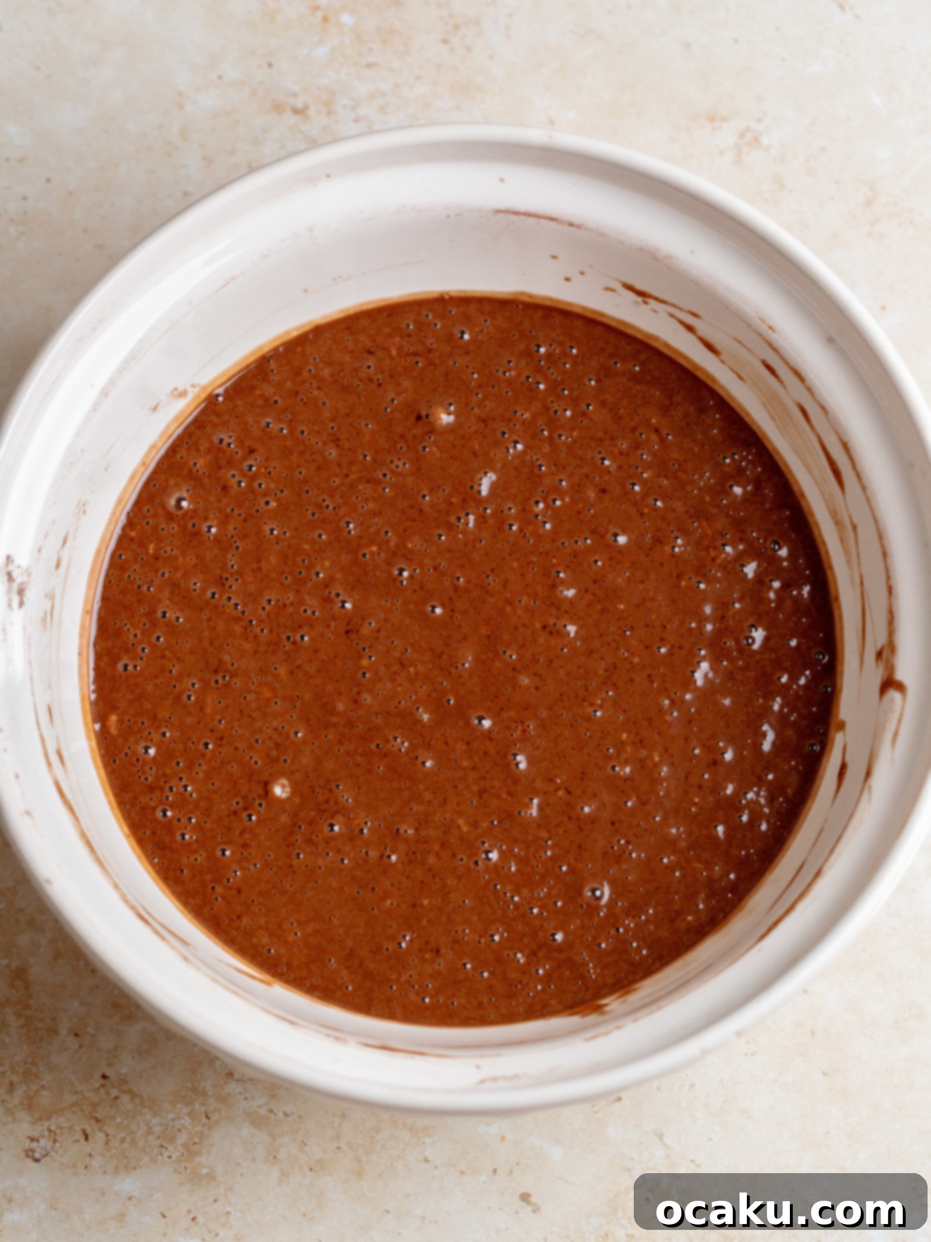 Wet ingredients being mixed in a bowl for chocolate coconut cake.