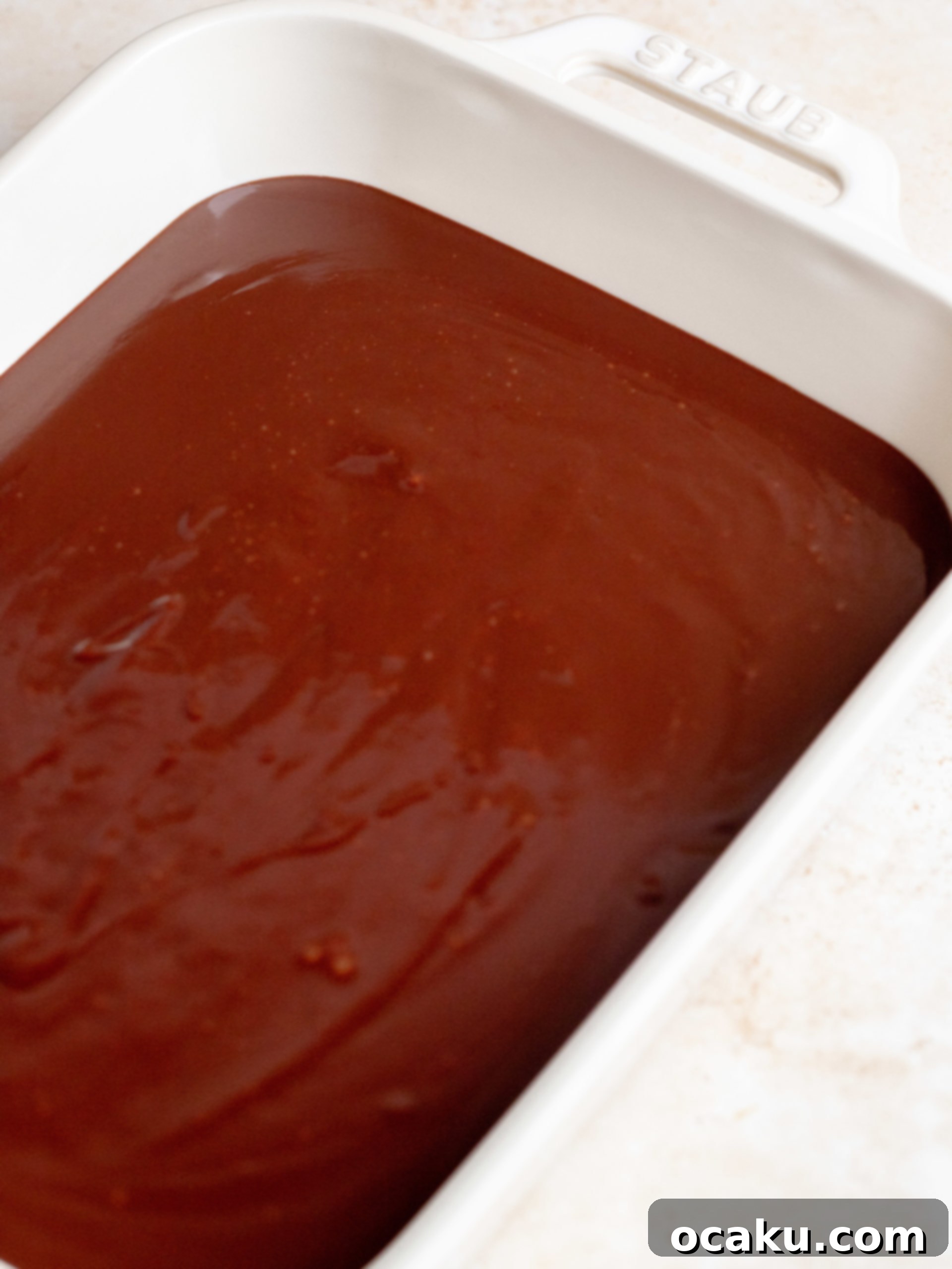 Chocolate ganache frosting cooling in a tray.