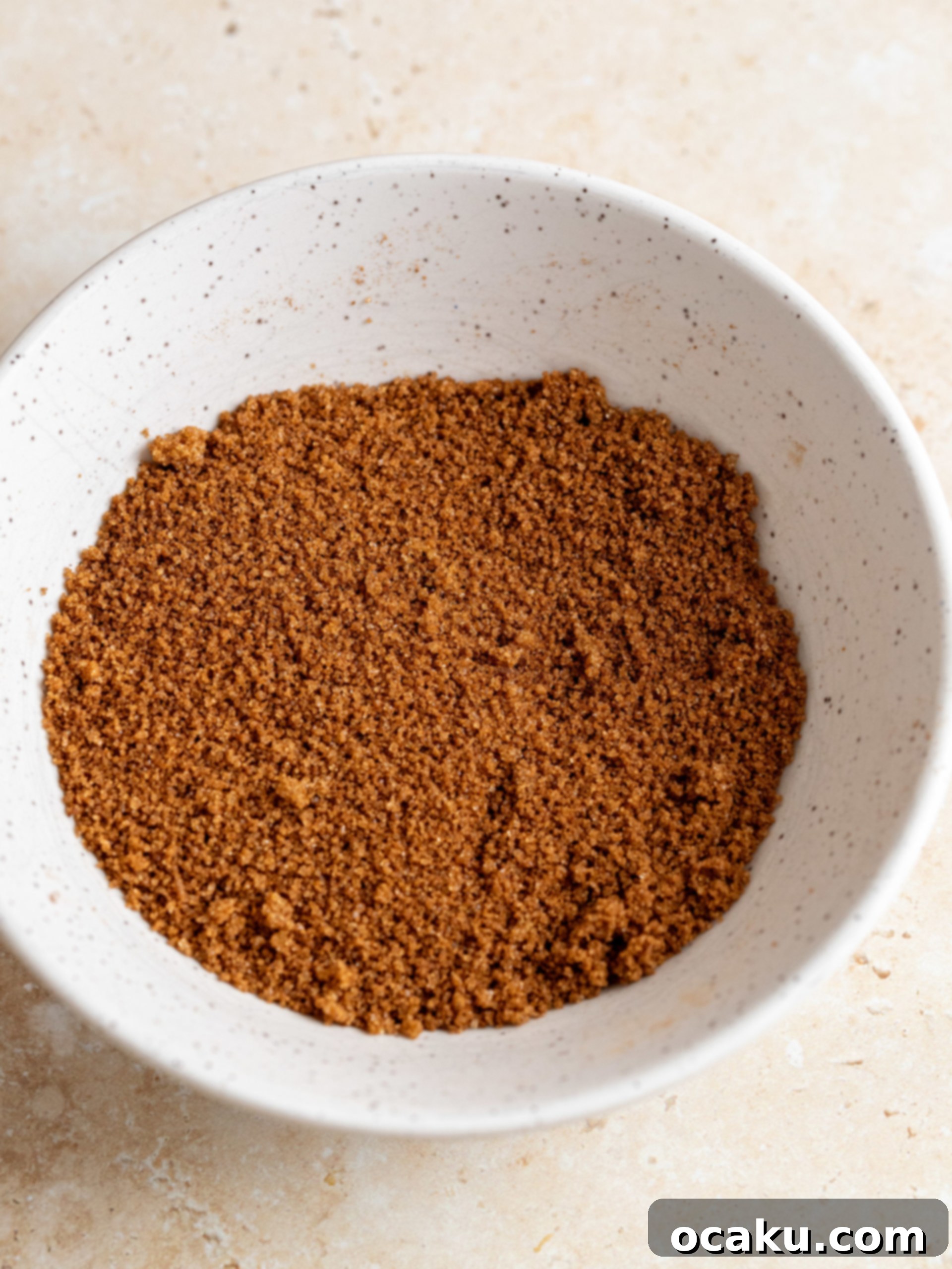Crust being pressed into a springform pan with the bottom of a glass