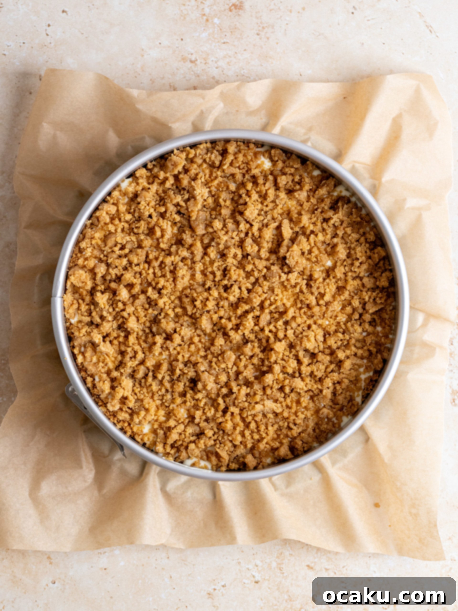 Assembling the Coffee Cake Cheesecake with layers of batter, cinnamon sugar, and crumble