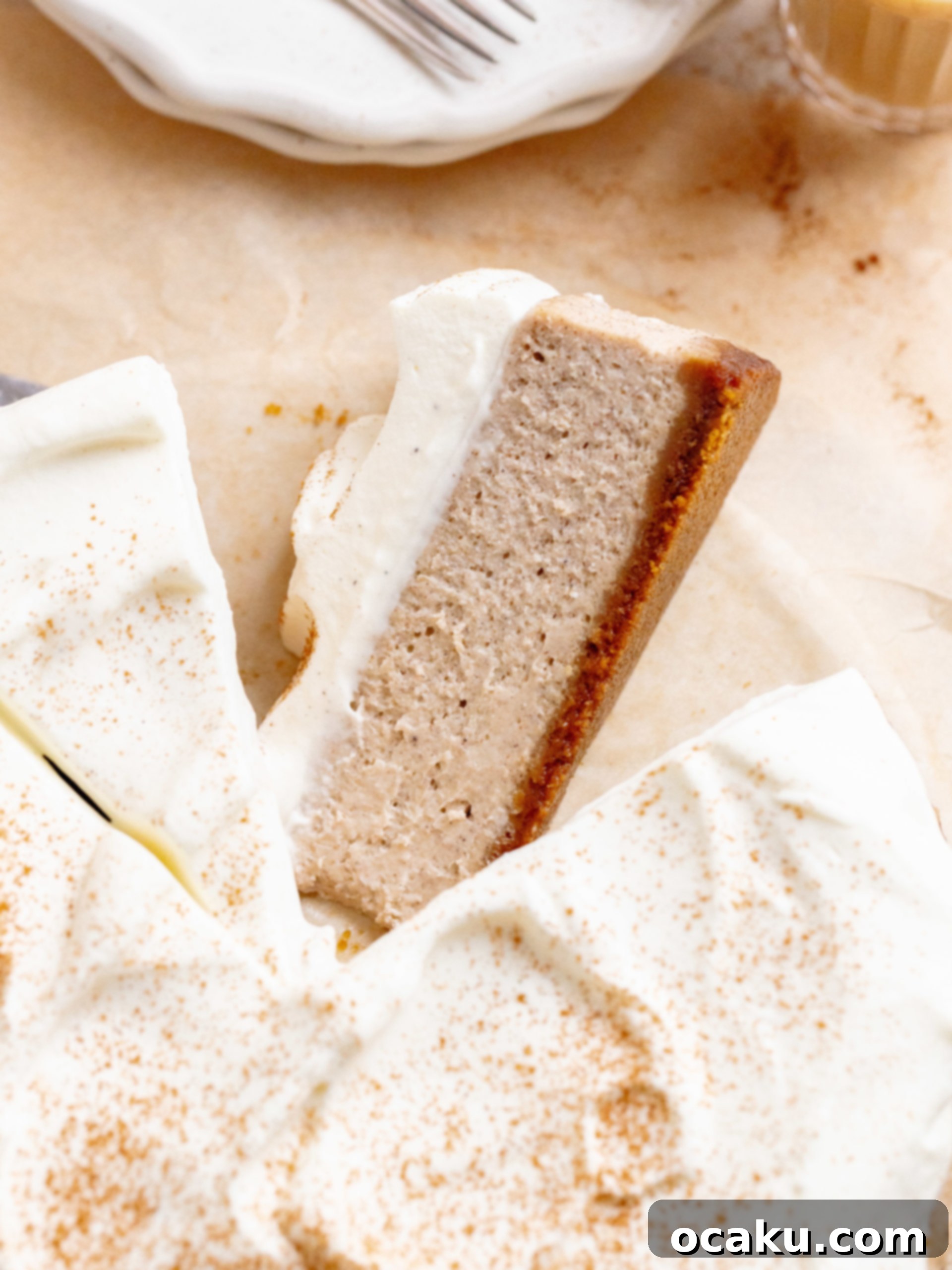 Chai Spice Cheesecake topped with whipped cream and a sprinkle of cinnamon, perfect for fall gatherings.