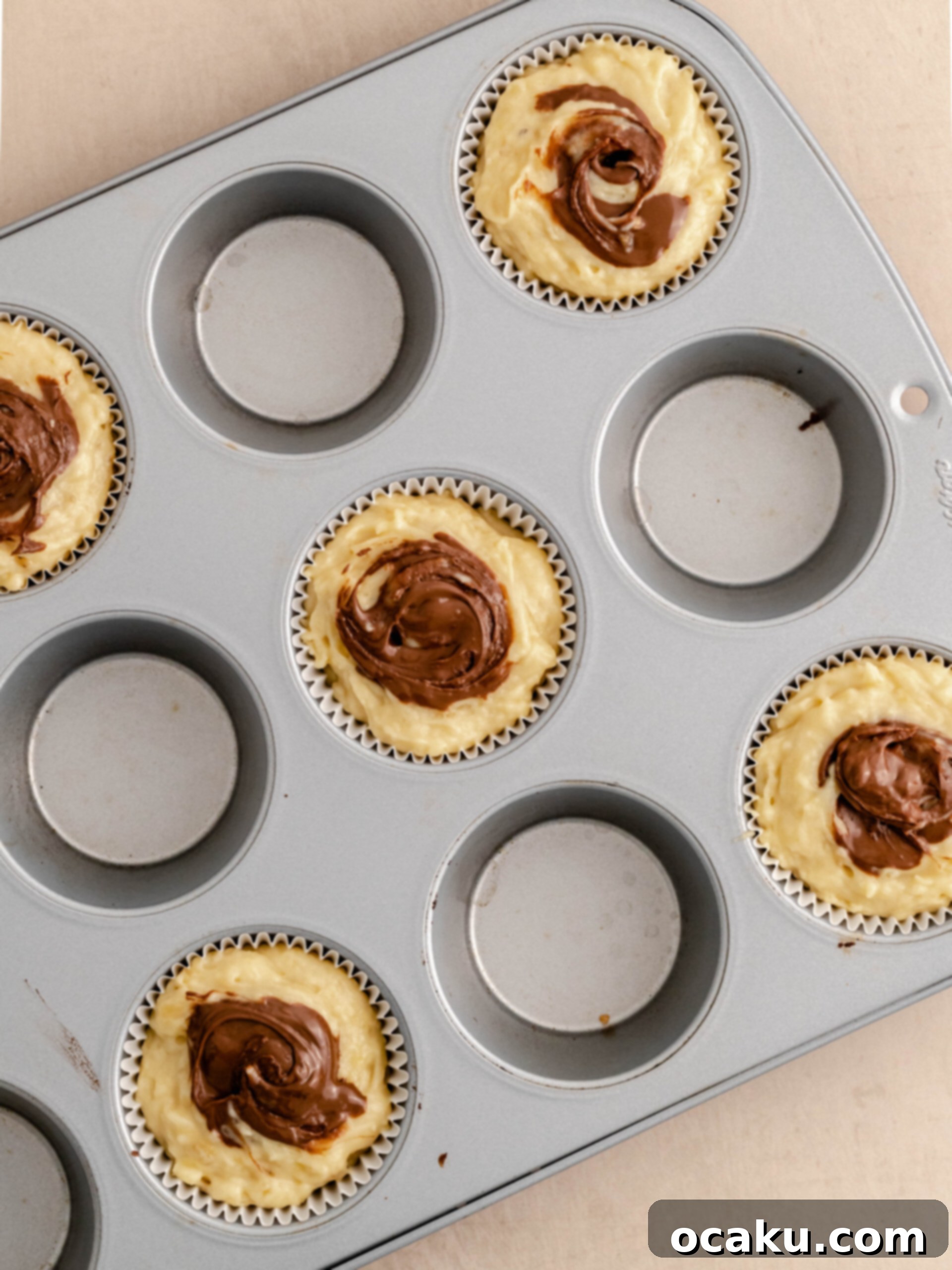 Swirling Nutella into the top of muffin batter before baking
