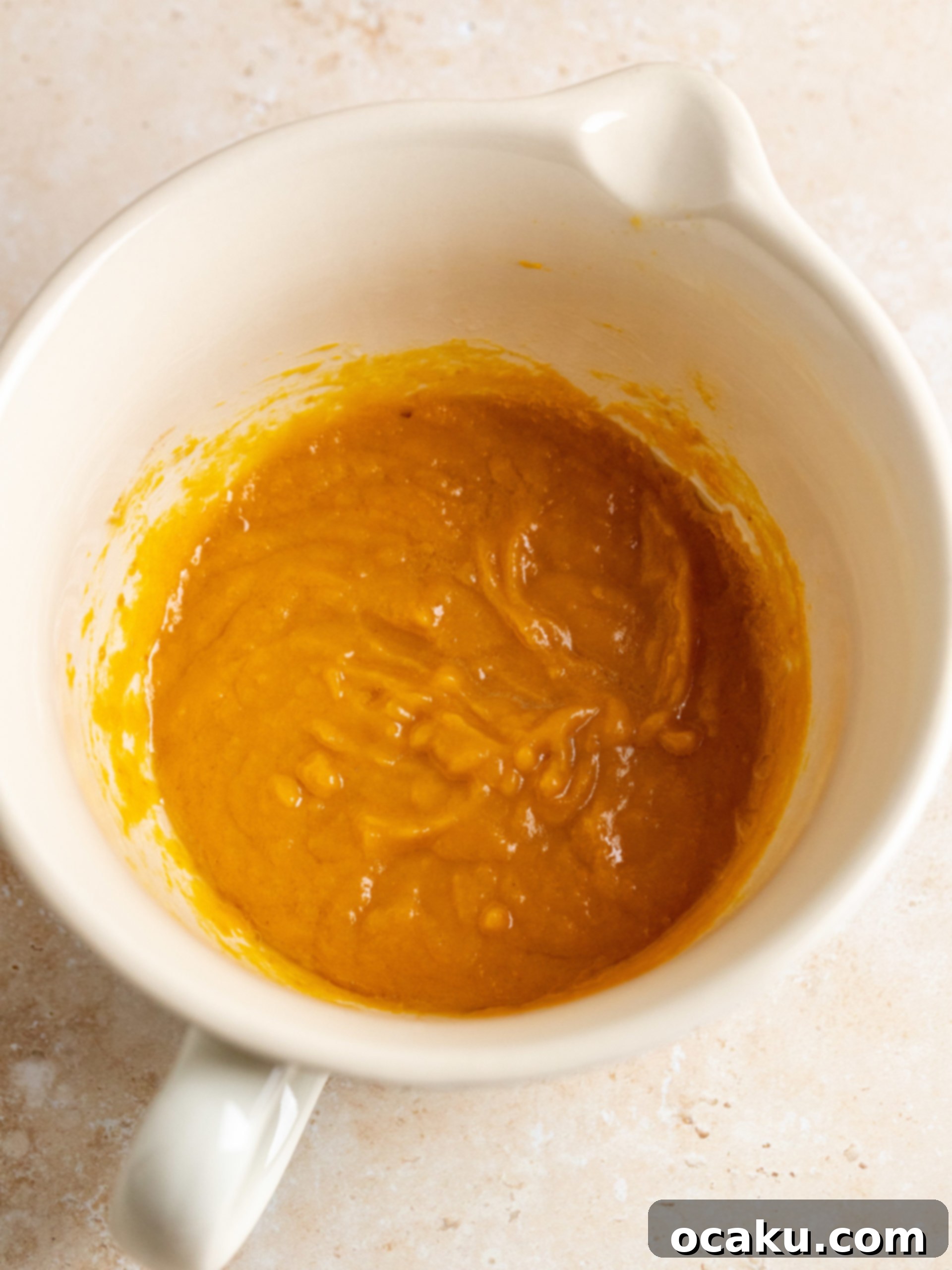 Wet ingredients for pumpkin muffins being whisked.