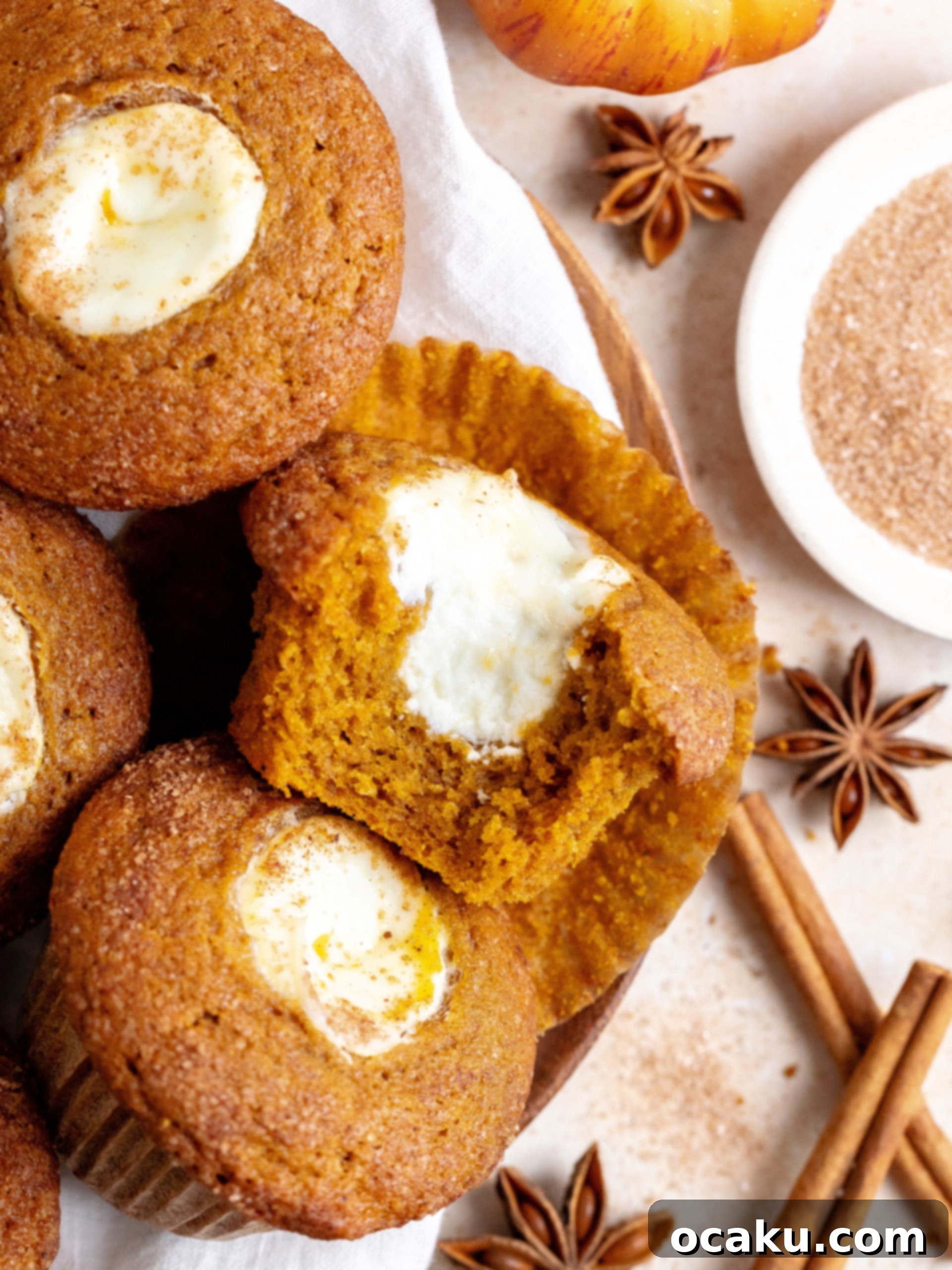 A freshly baked pumpkin cream cheese muffin, showing the fluffy interior.
