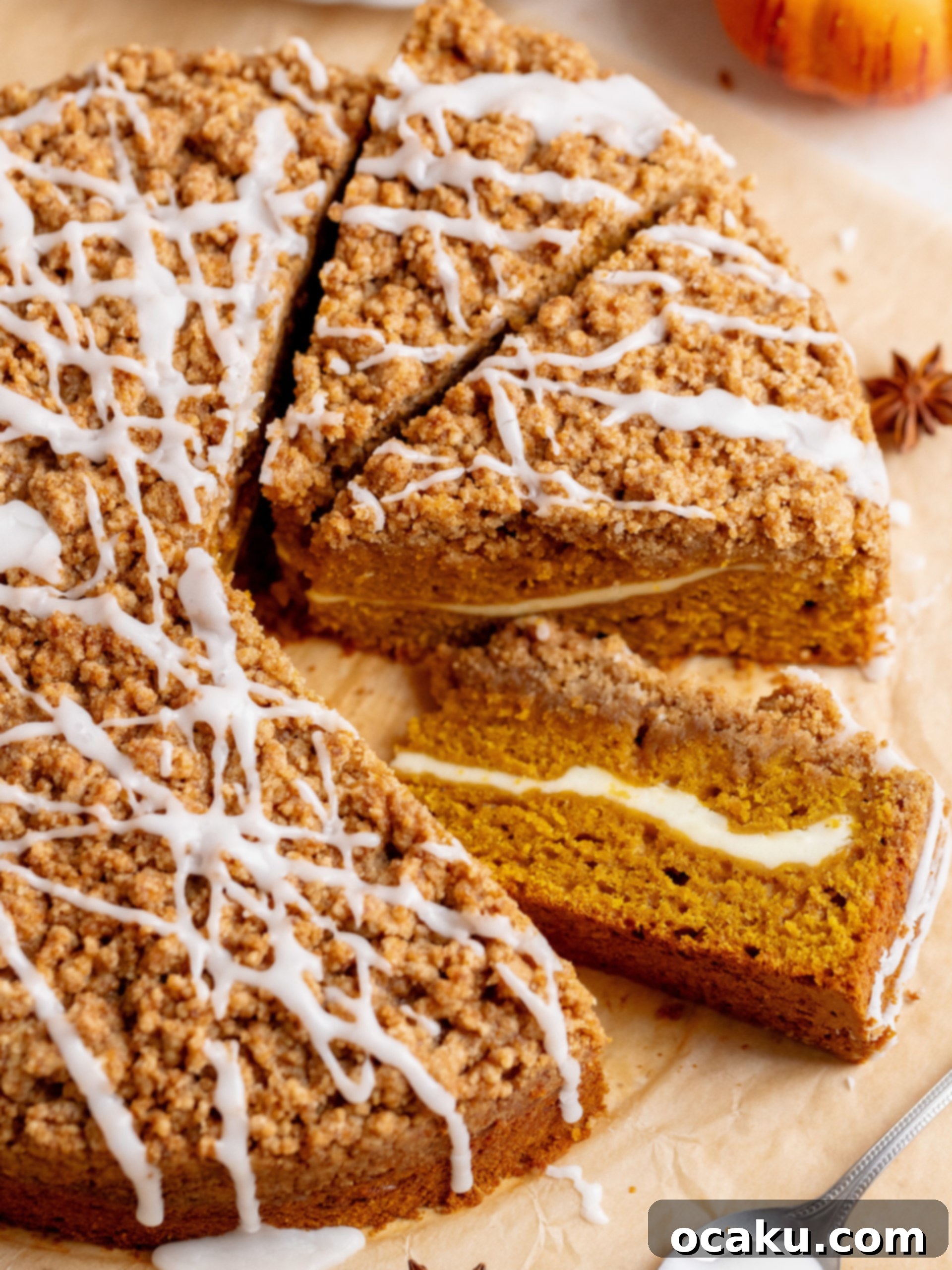 A slice of Pumpkin Coffee Cake with Cream Cheese, showing the layers of cake, cream cheese swirl, and streusel topping.