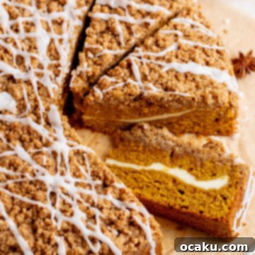 A delicious slice of homemade Pumpkin Coffee Cake with a visible cream cheese swirl and streusel topping.