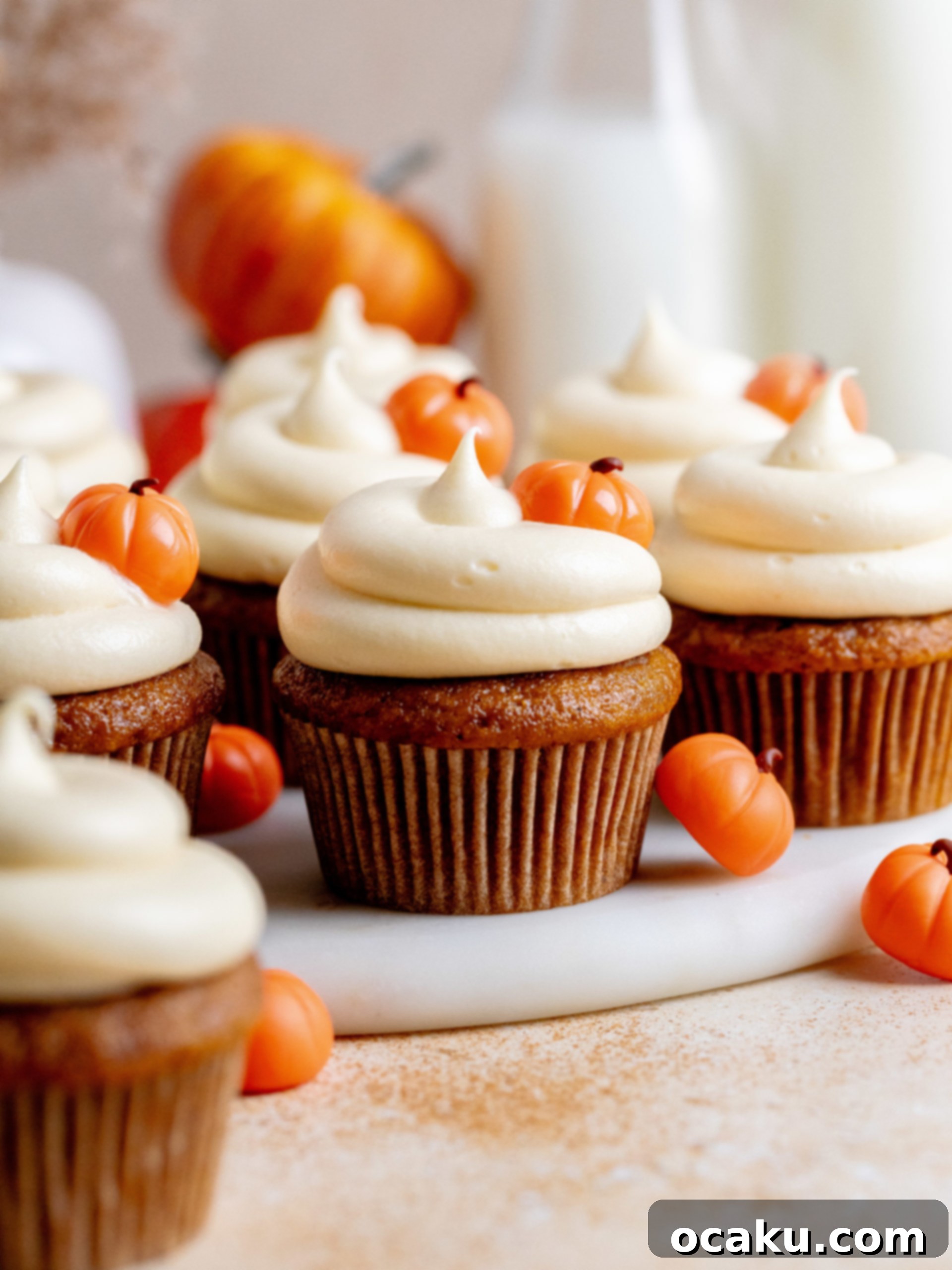 Close-up of a beautifully frosted pumpkin cupcake, ready to eat.