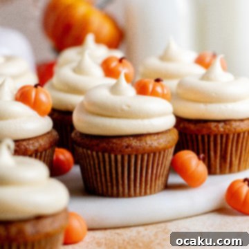 A selection of pumpkin cupcakes with generous swirls of cream cheese frosting.