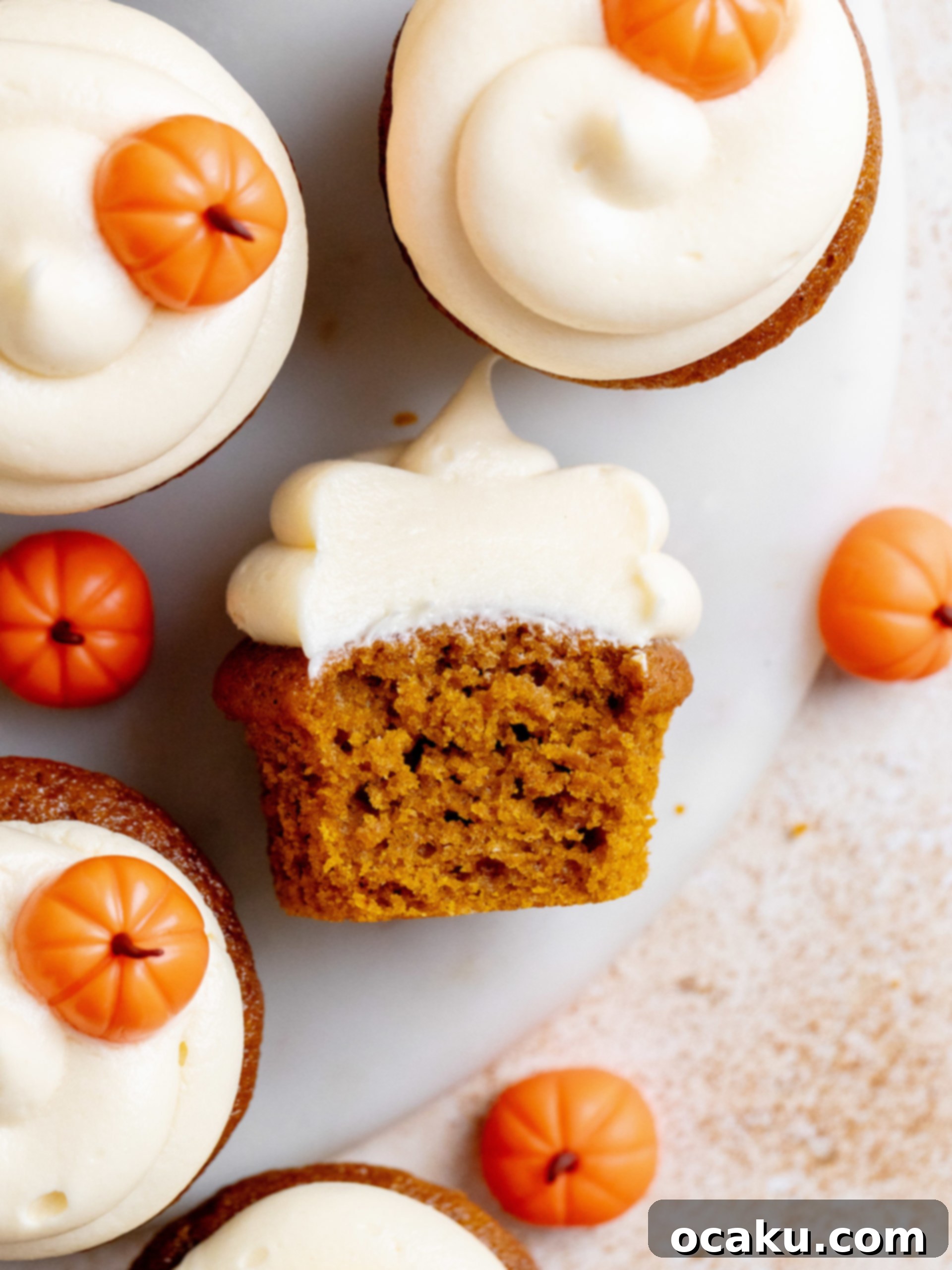 Three pumpkin cupcakes with detailed fondant pumpkin decorations.