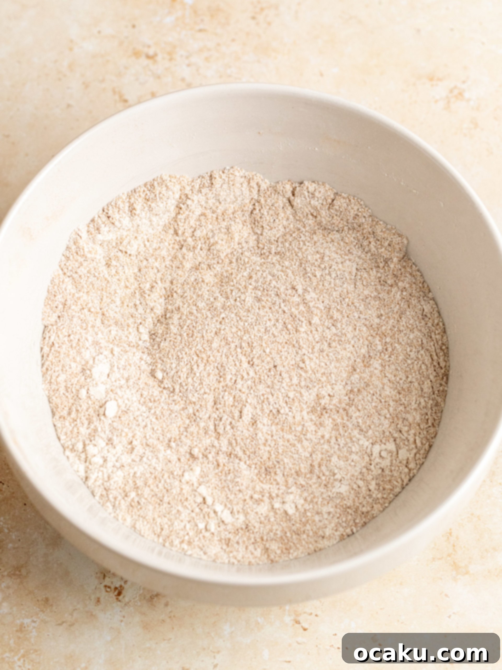 Wet ingredients being poured into dry ingredients for cupcake batter.