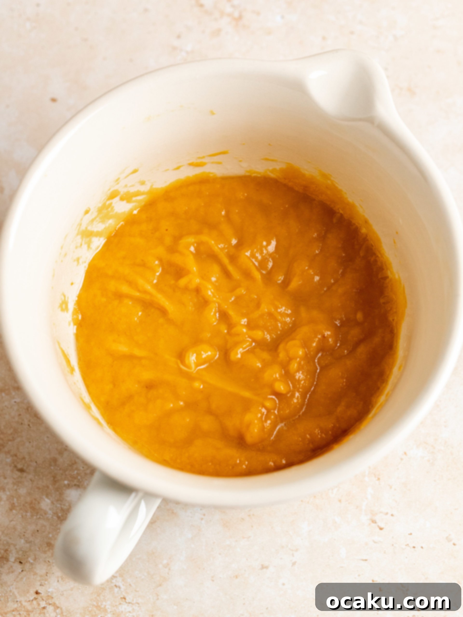 Cupcake batter being scooped into paper liners.