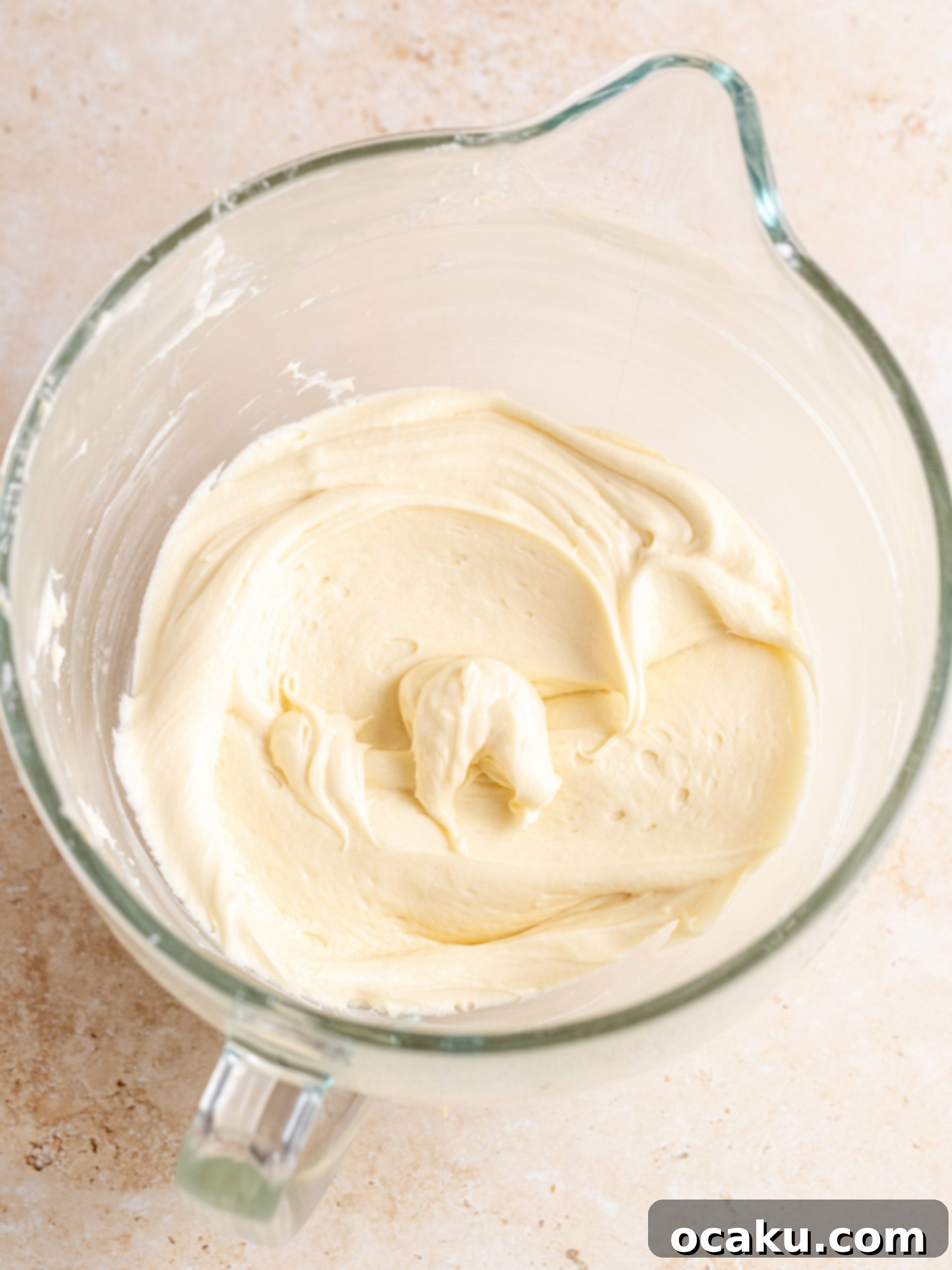 Powdered sugar being added to the frosting in two parts.