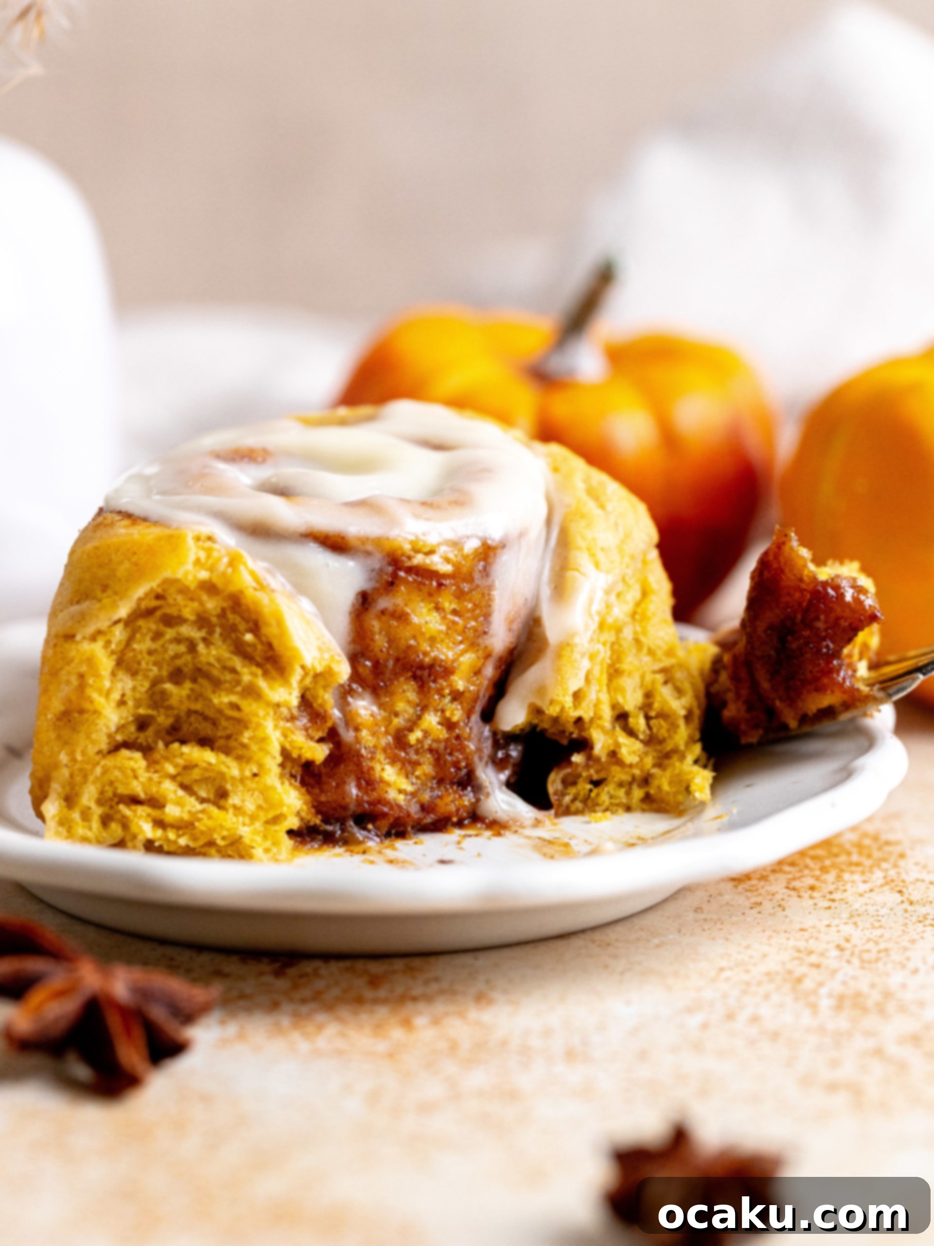 Close-up of a stack of pumpkin cinnamon rolls on a rustic board.
