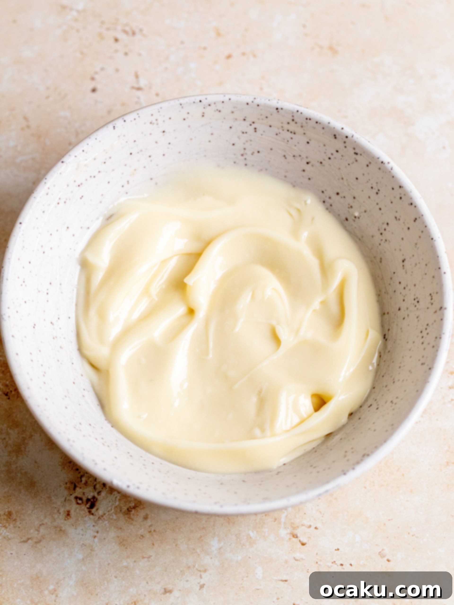 Baked pumpkin cinnamon rolls with heavy cream poured over.