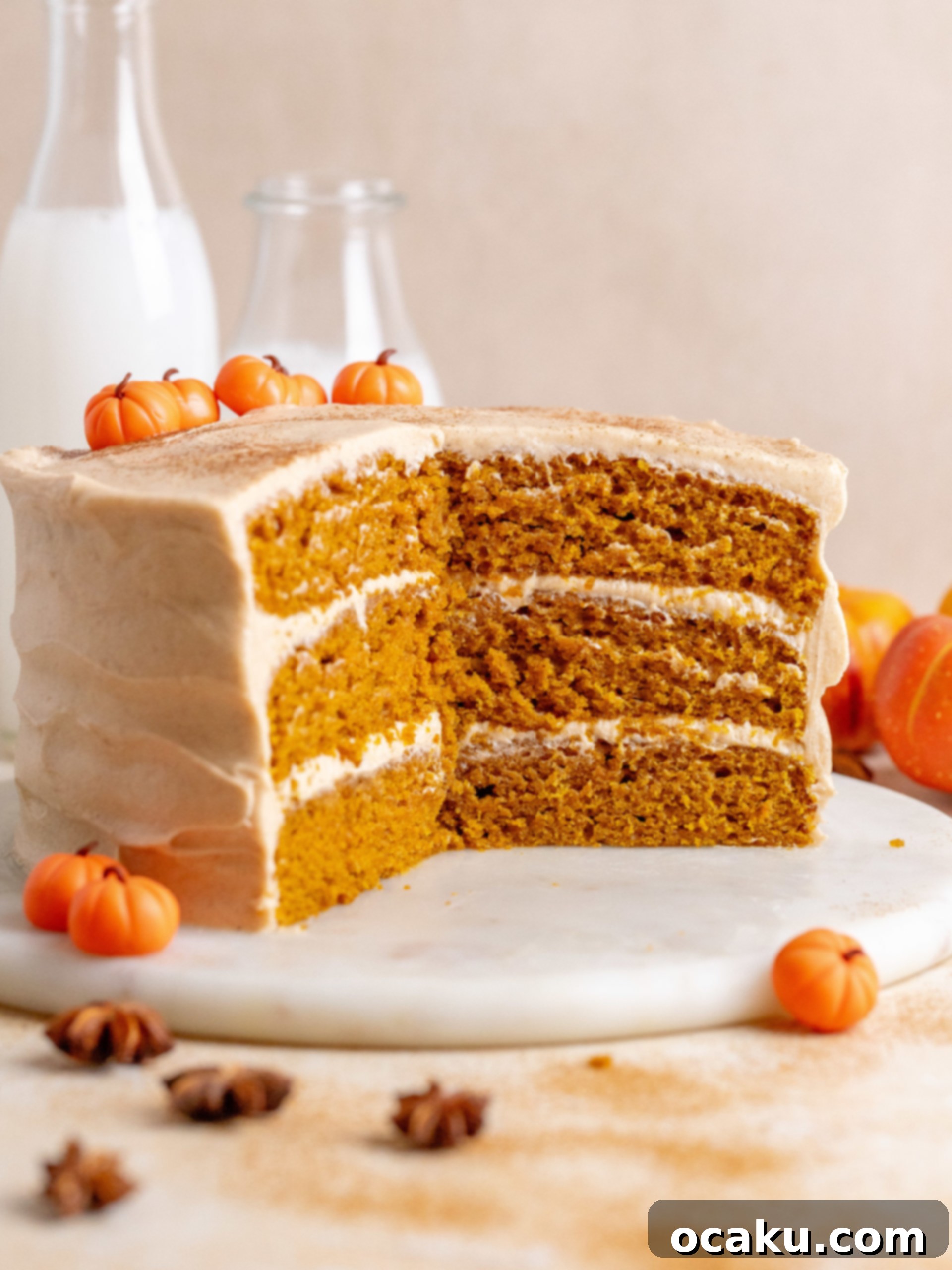 Two pumpkin cake layers stacked with cream cheese frosting, ready for more frosting
