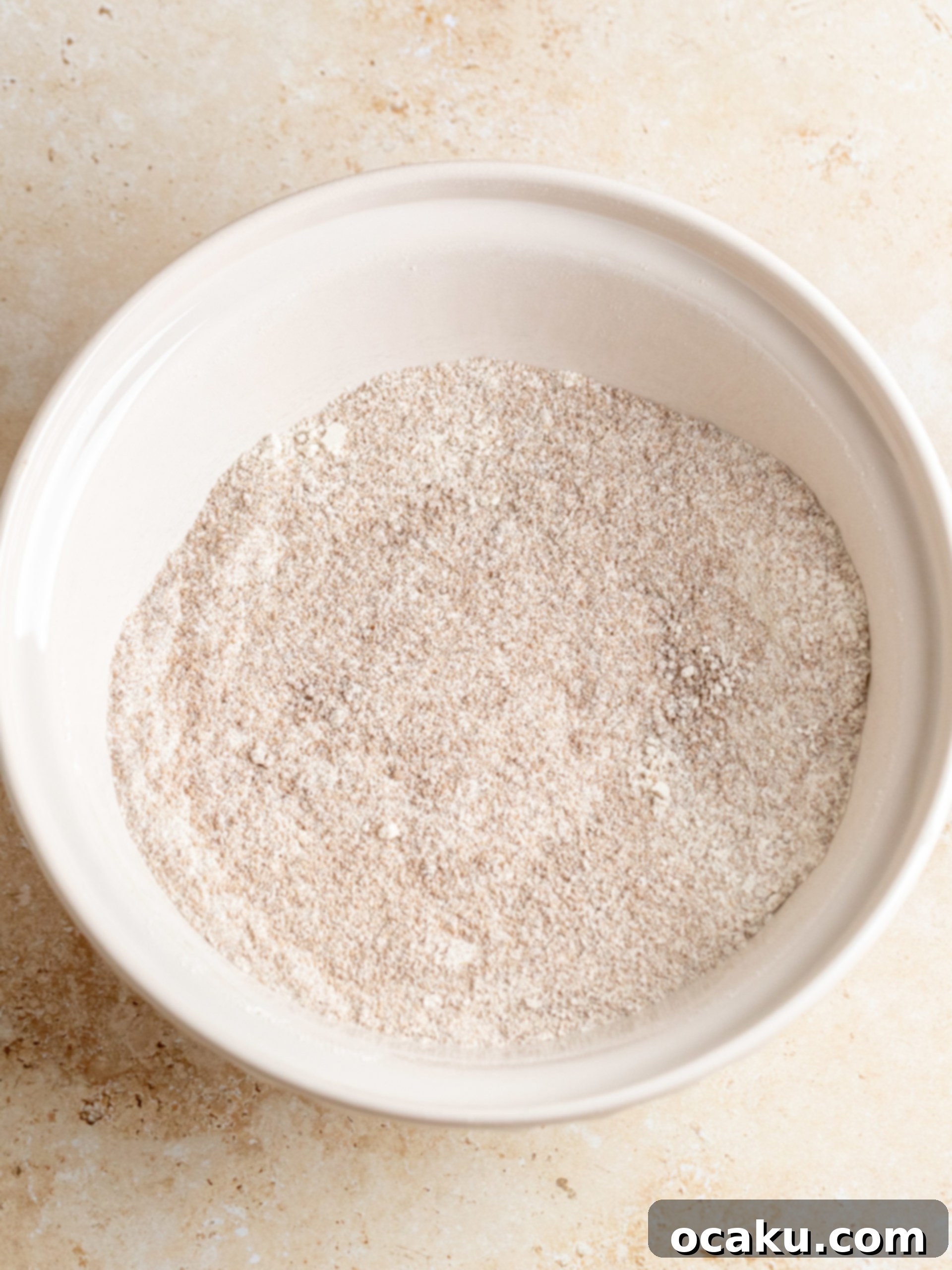 Wet ingredients being poured into dry ingredients for pumpkin cake batter