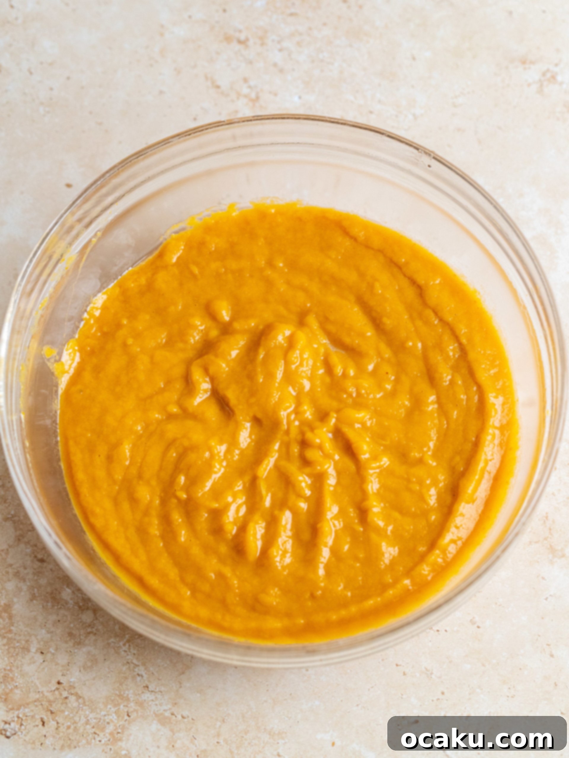 Pumpkin cake batter divided evenly into three round baking pans