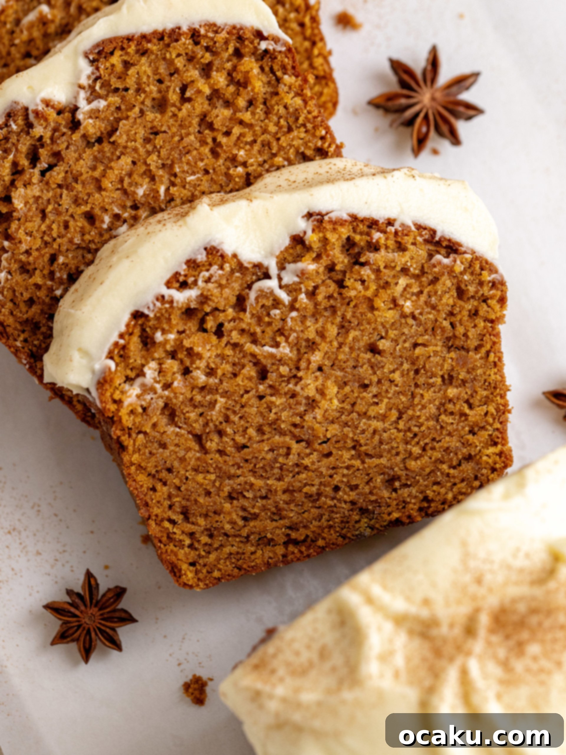 Two slices of sweet potato bread with cream cheese frosting, one leaning against the other, showing the moist texture.