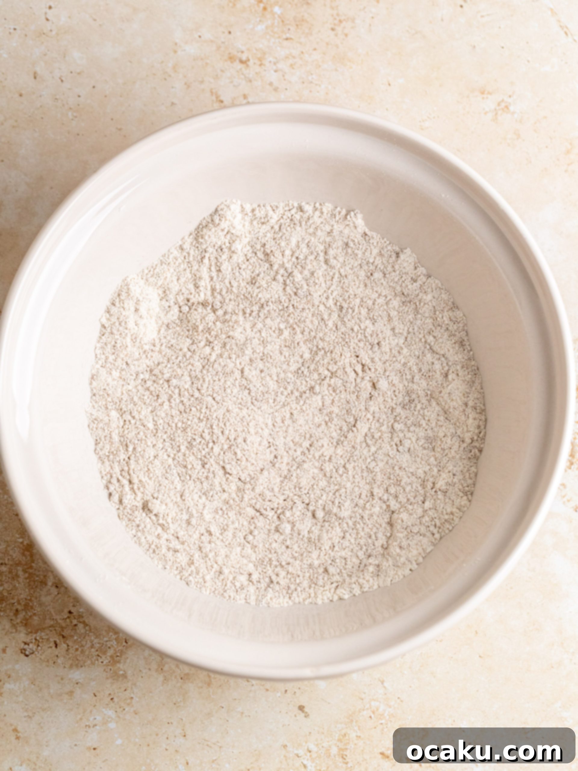 Mixing dry ingredients in a bowl for sweet potato bread.