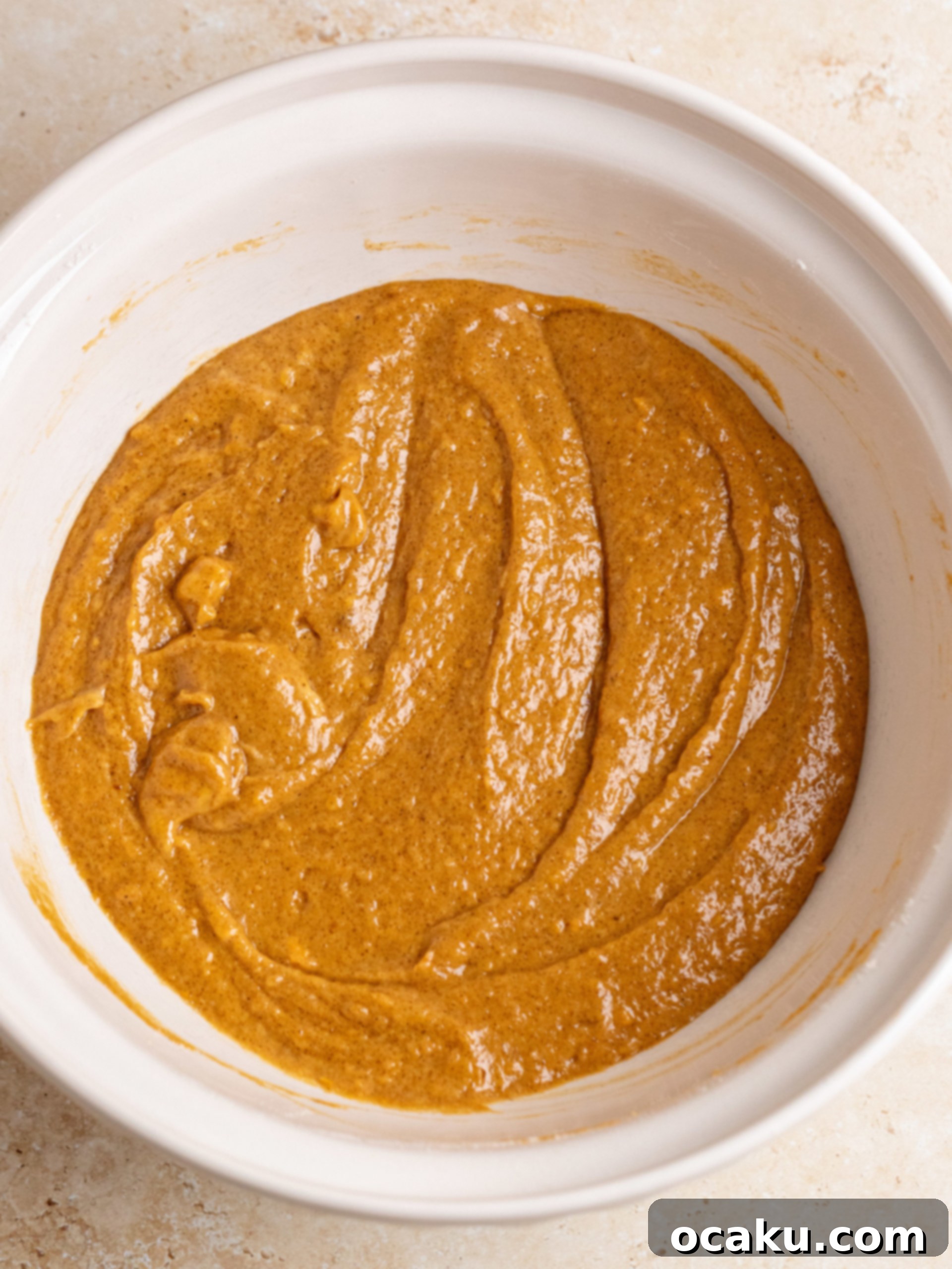 Cream cheese frosting being spread on the cooled sweet potato bread.