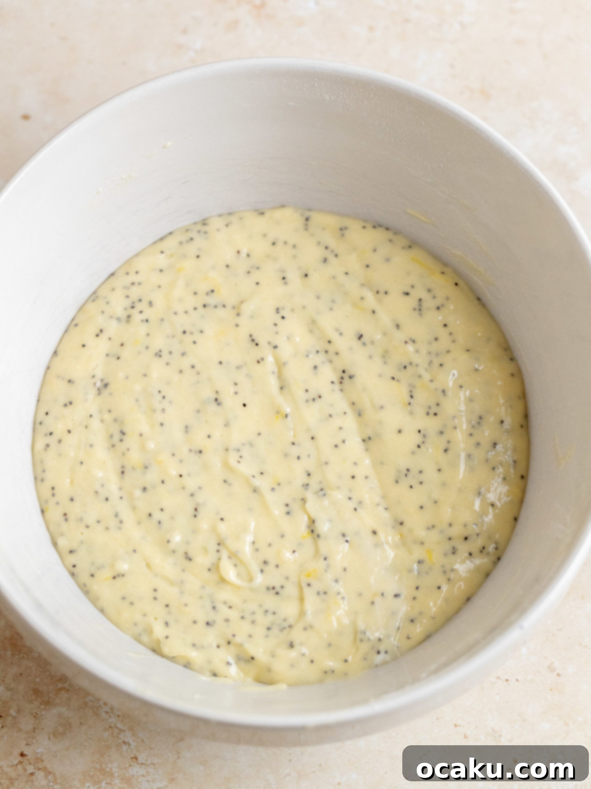 Lemon zest rubbed with sugar, resembling wet sand, in a mixing bowl.