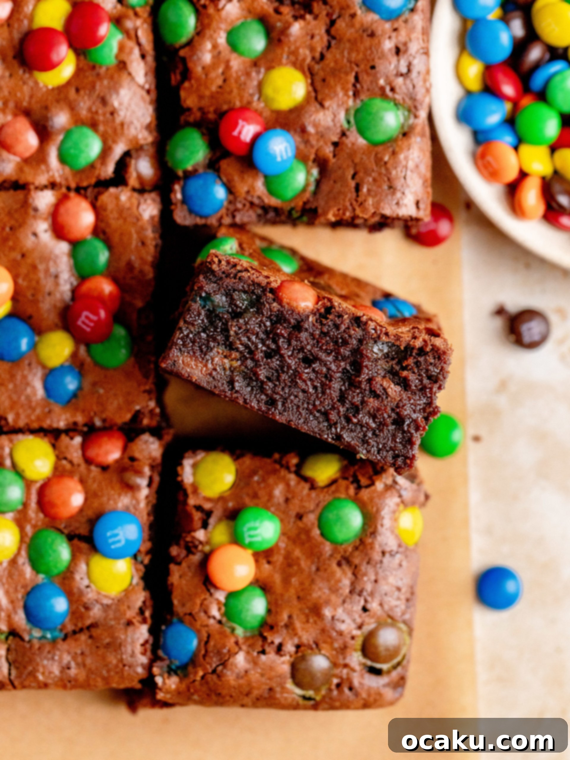 M&M Brownies 3 A close-up shot of a freshly baked M&M brownie, still in the pan, showing its crinkly top and colorful candies.
