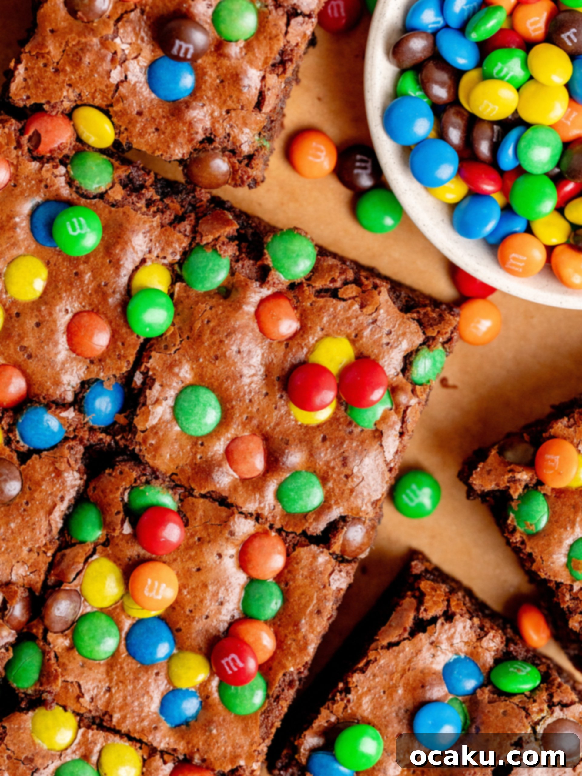 M&M Brownies 8 A stack of three M&M brownies, perfectly cut and showing off their colorful centers, on a wooden board.