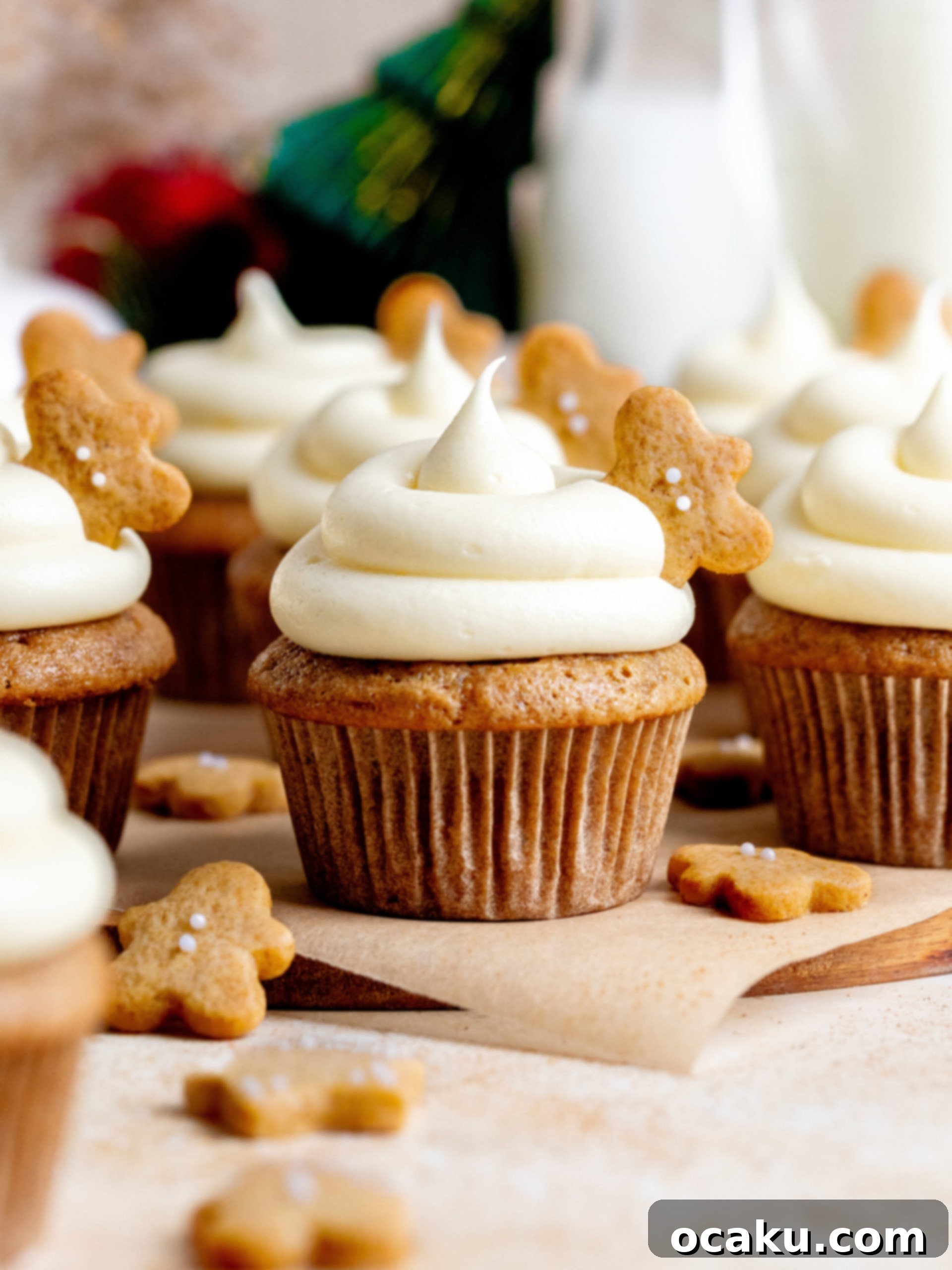 A perfectly piped gingerbread cupcake with cream cheese frosting and a mini gingerbread man cookie on top.