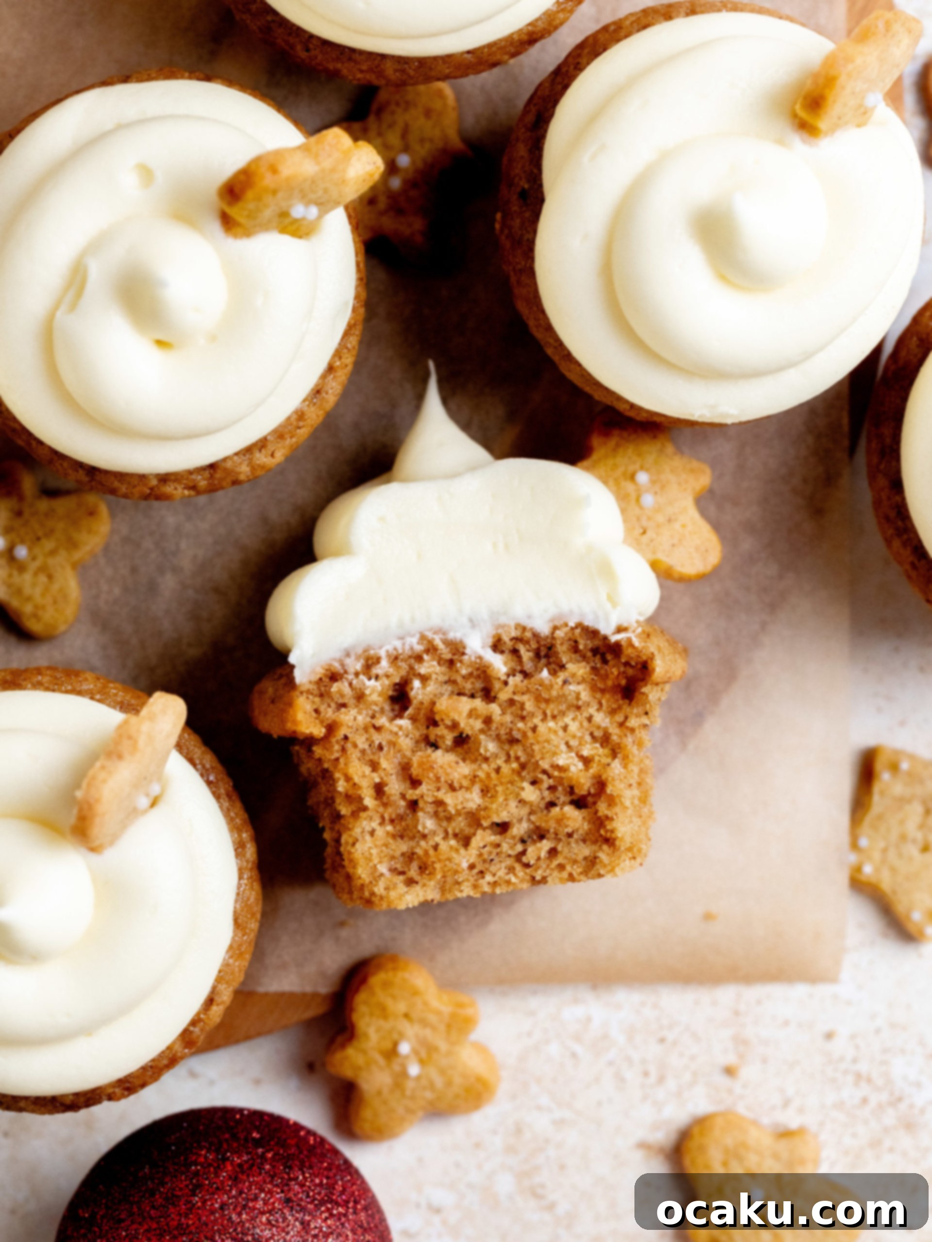 Close-up of a gingerbread cupcake with cream cheese frosting and a mini gingerbread man cookie.