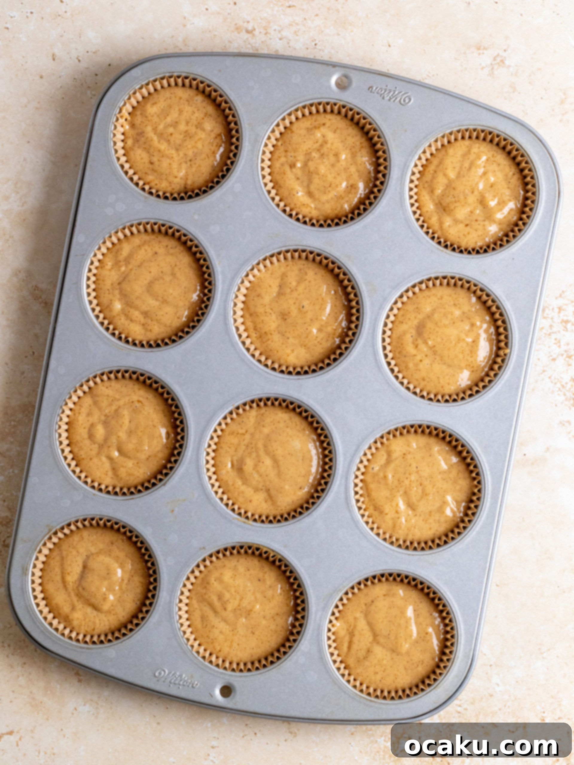 Step-by-step image of dividing batter into cupcake liners.