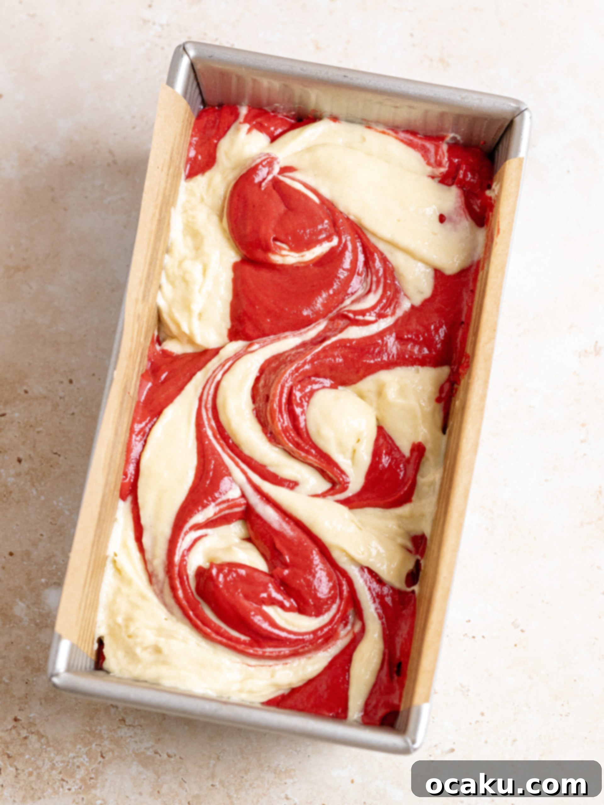 Spoonfuls of batter being added to a loaf pan.
