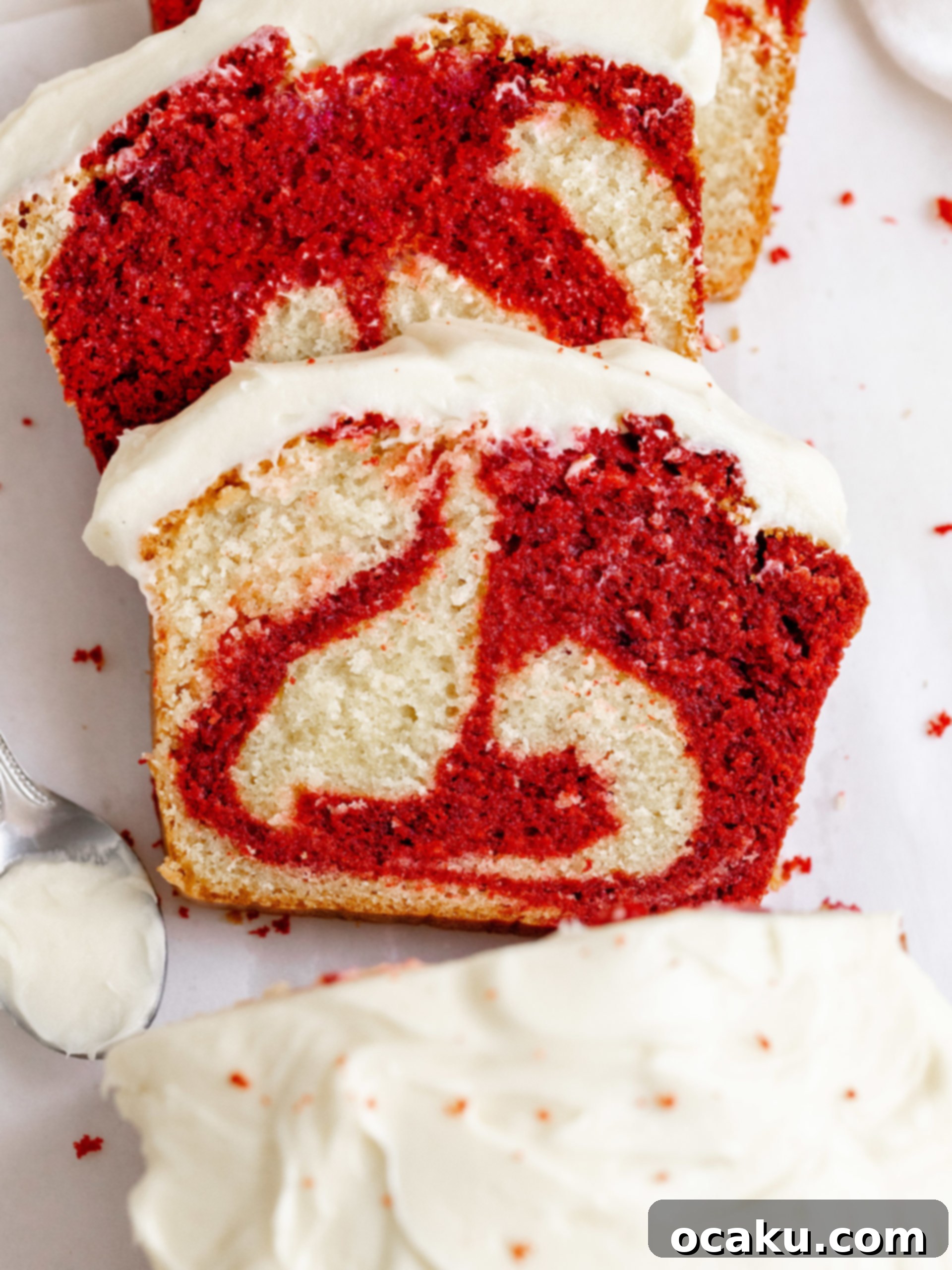 A whole red velvet loaf cake on a wire rack, with some slices taken.