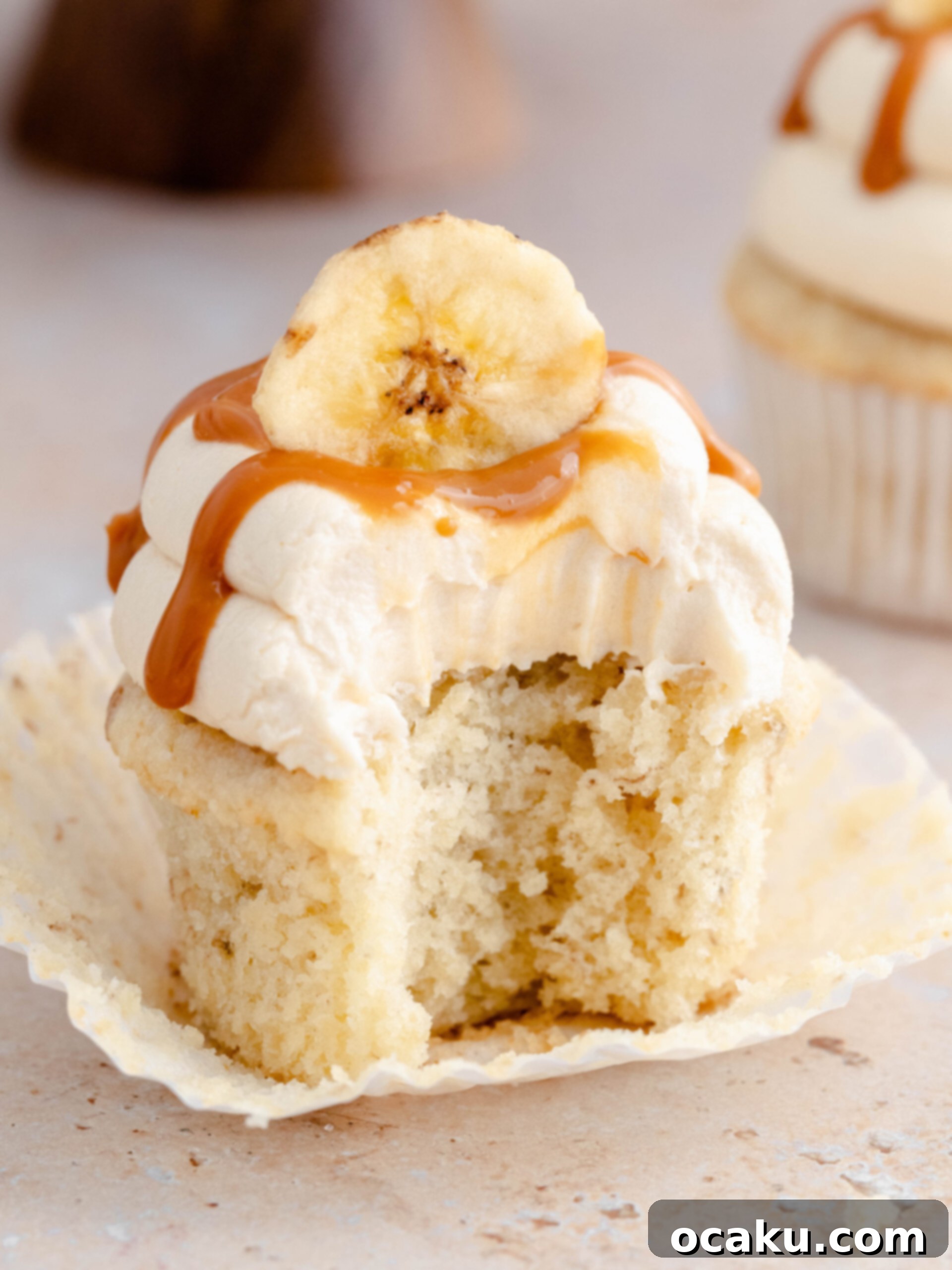 Dreamy Banoffee Cupcakes 3 A banoffee cupcake with a bite taken, showing the fluffy cake and creamy frosting.
