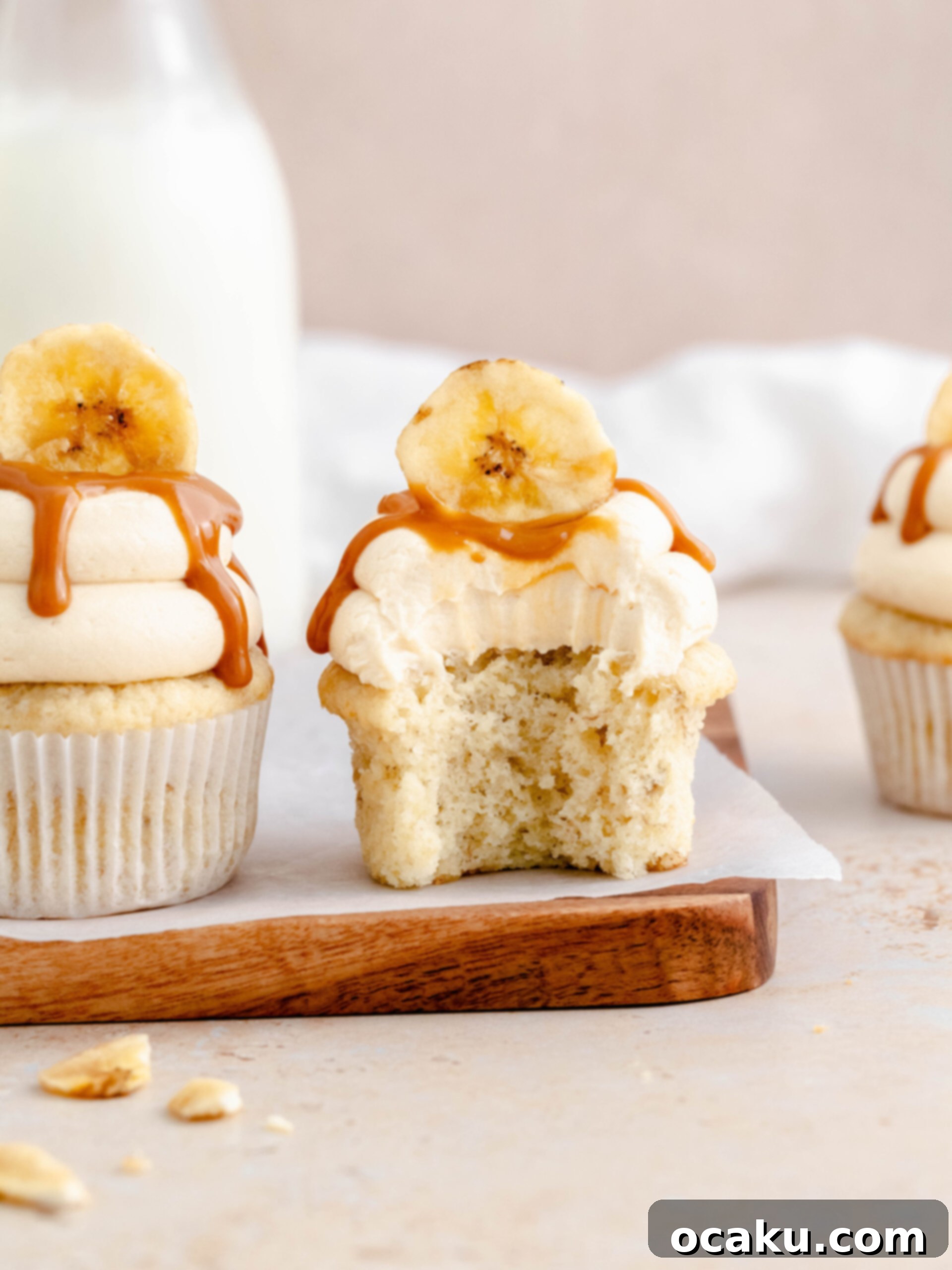 Dreamy Banoffee Cupcakes 5 Close-up of a decorated banoffee cupcake with dulce de leche drizzle and a banana chip.