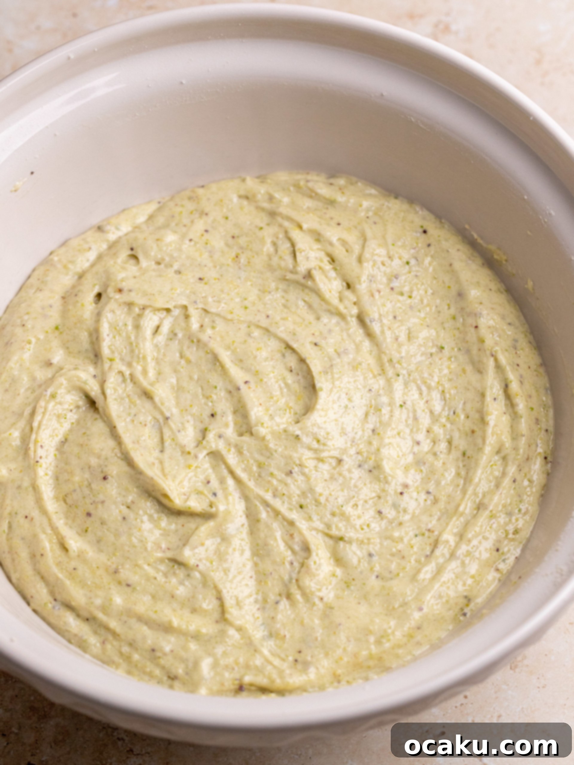 The process of blending pistachios into a fine flour, a key step for flavorful cake layers.