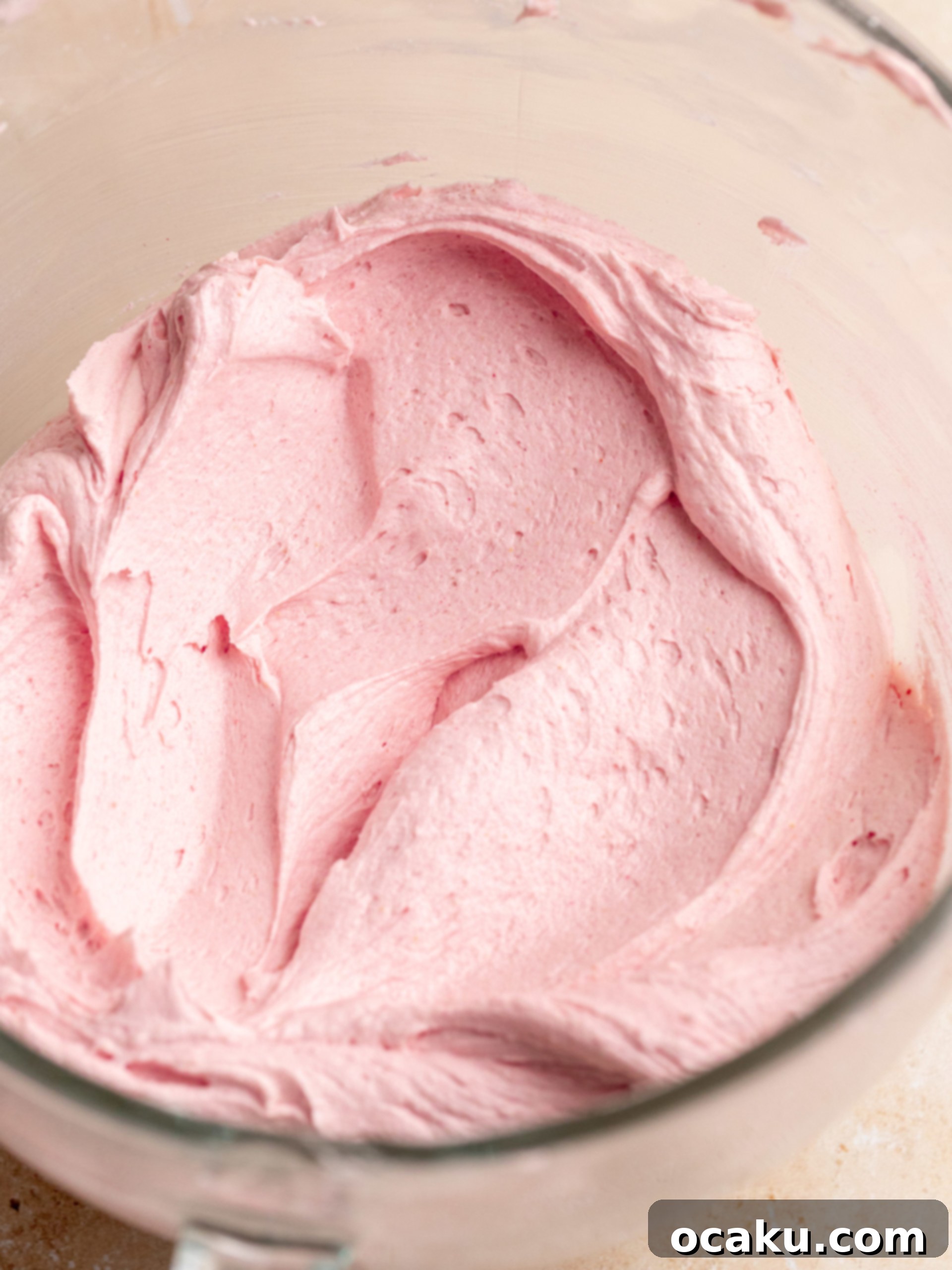 Homemade raspberry jam simmering in a saucepan, showing the fruit breaking down and thickening.