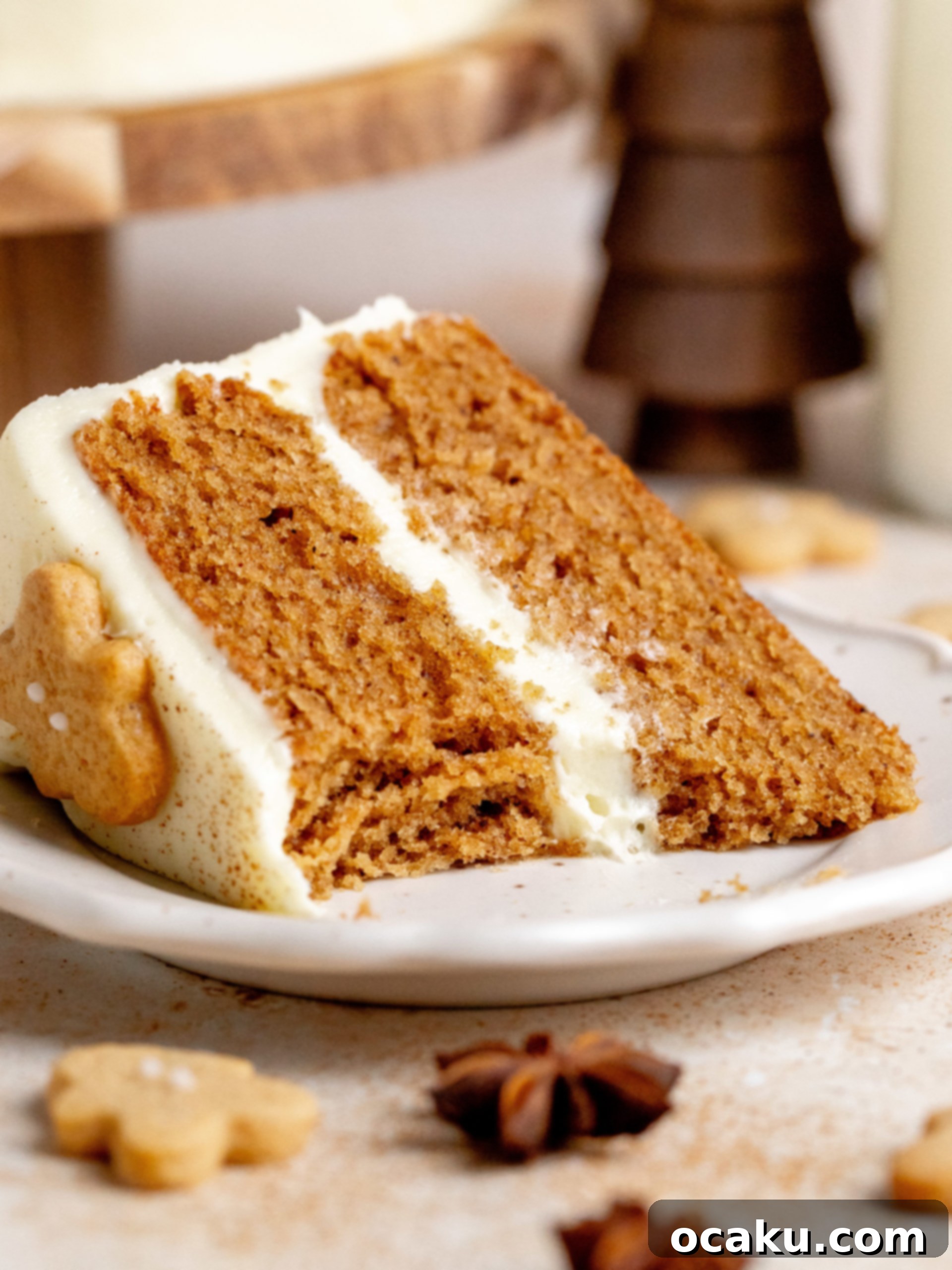 A close-up shot of a slice of Gingerbread Layer Cake on a plate, with a fork, ready to be eaten.