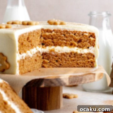 A festive Gingerbread Layer Cake with tangy cream cheese frosting and mini gingerbread cookies.
