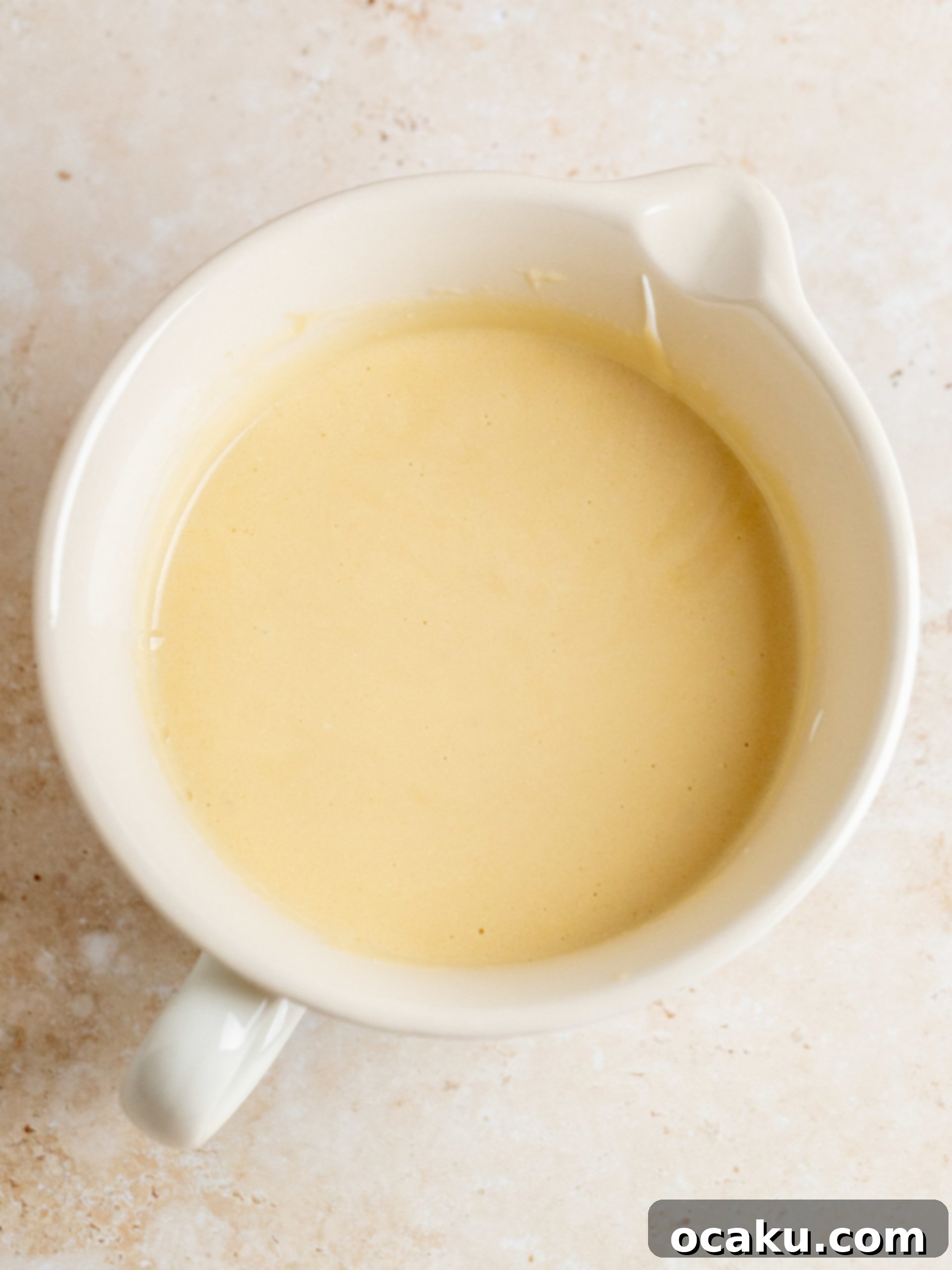 Two baked gingerbread cake layers cooling on a wire rack, ready for frosting.