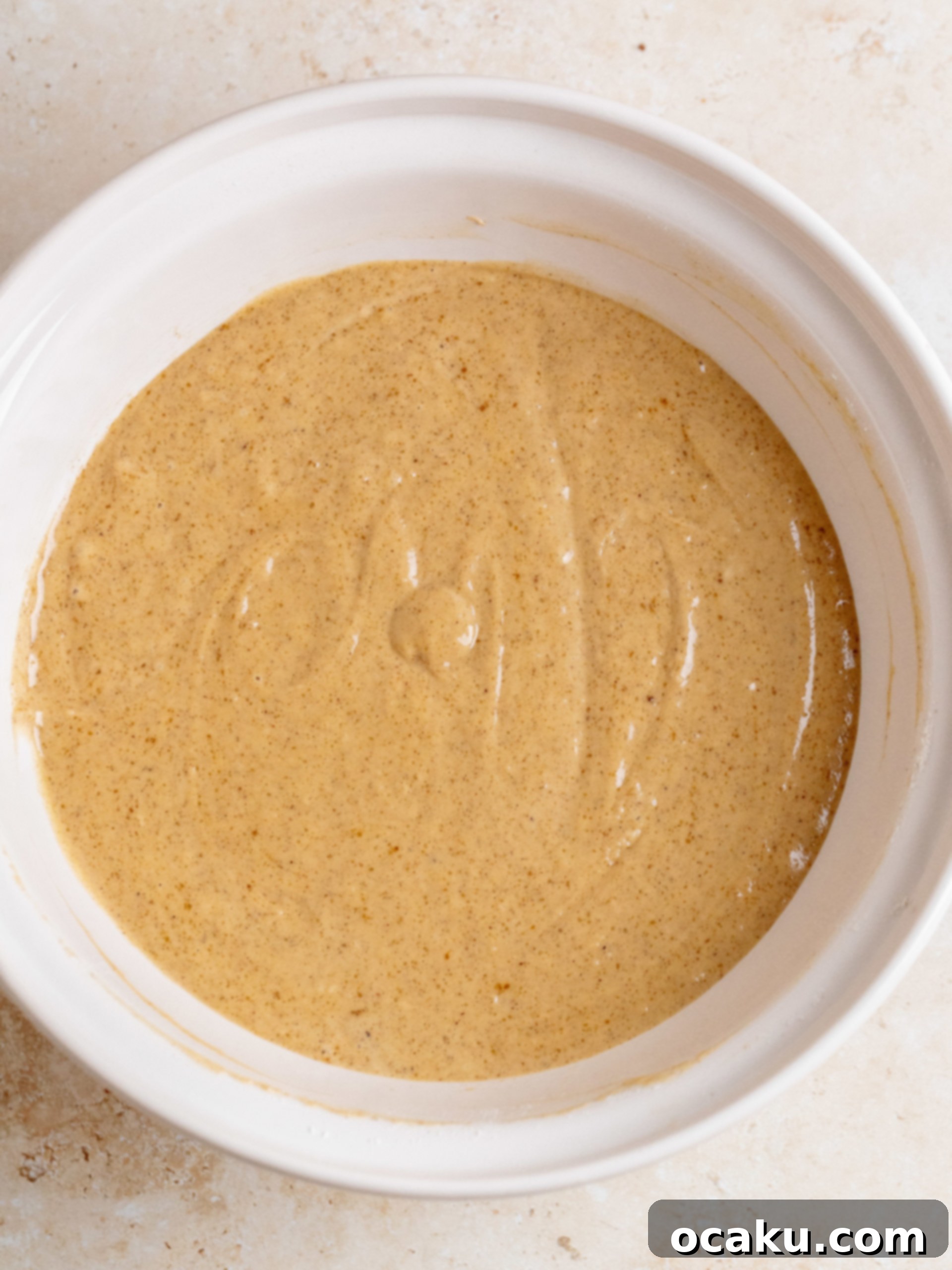 Close-up of the smooth, tangy cream cheese frosting being prepared in a stand mixer.