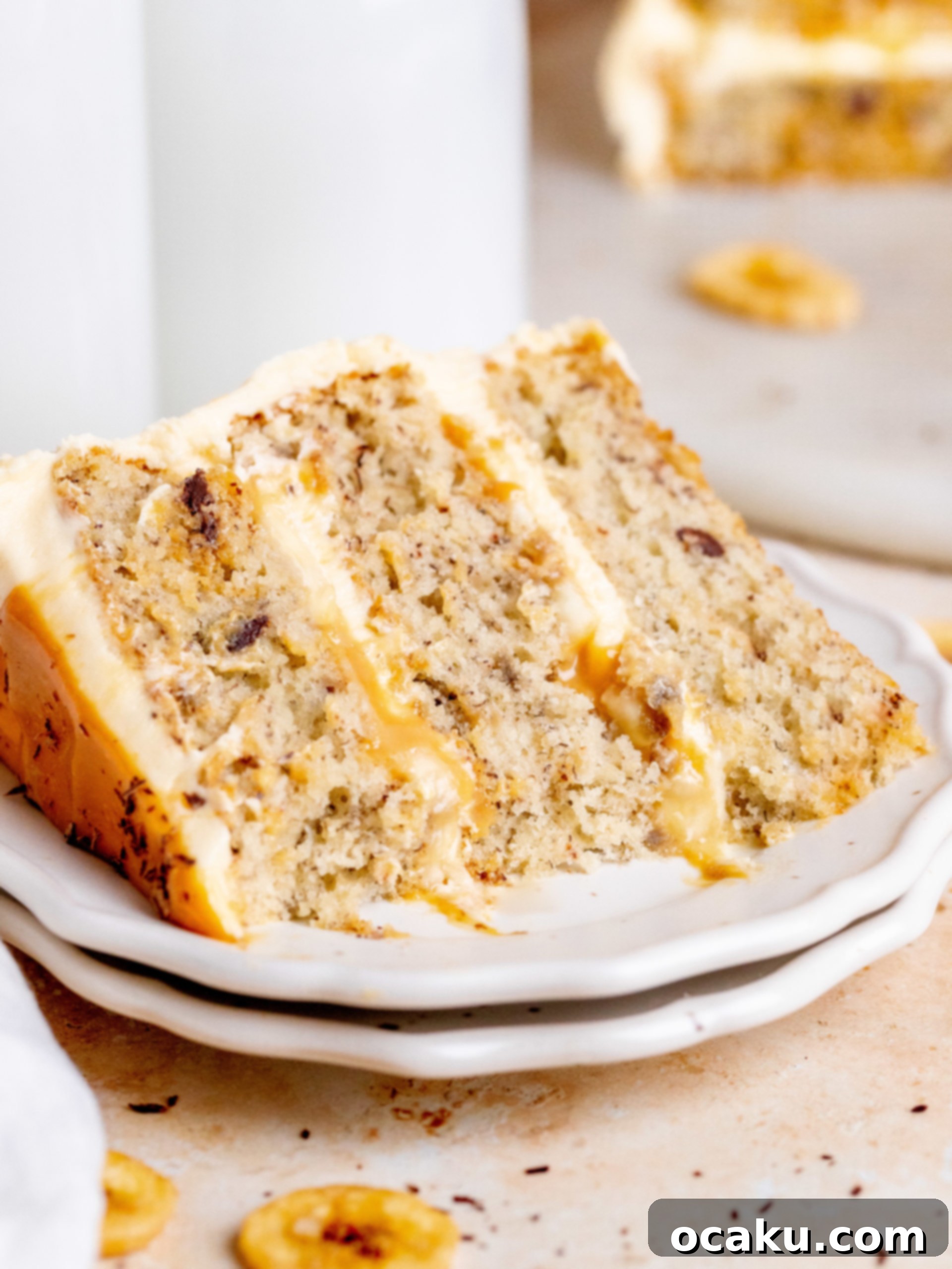Close-up of the delicious Banoffee Layer Cake showing a generous filling of dulce de leche and fresh banana slices between moist banana cake layers.